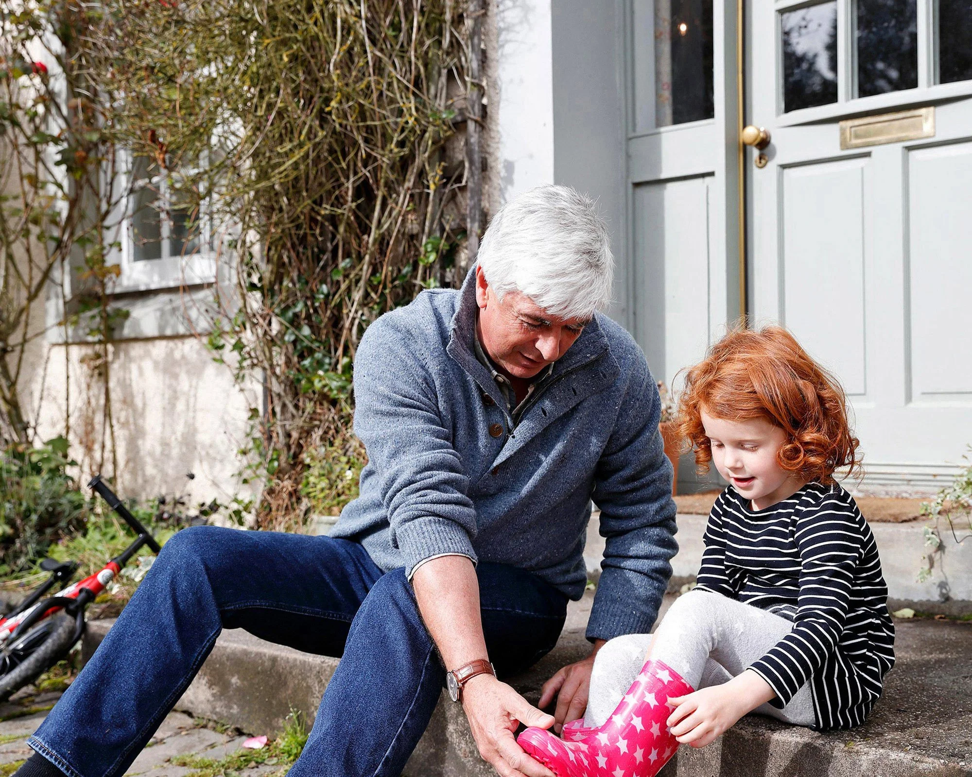 grandfather-helping-his-grandaughter-put-on-her-boots.jpg