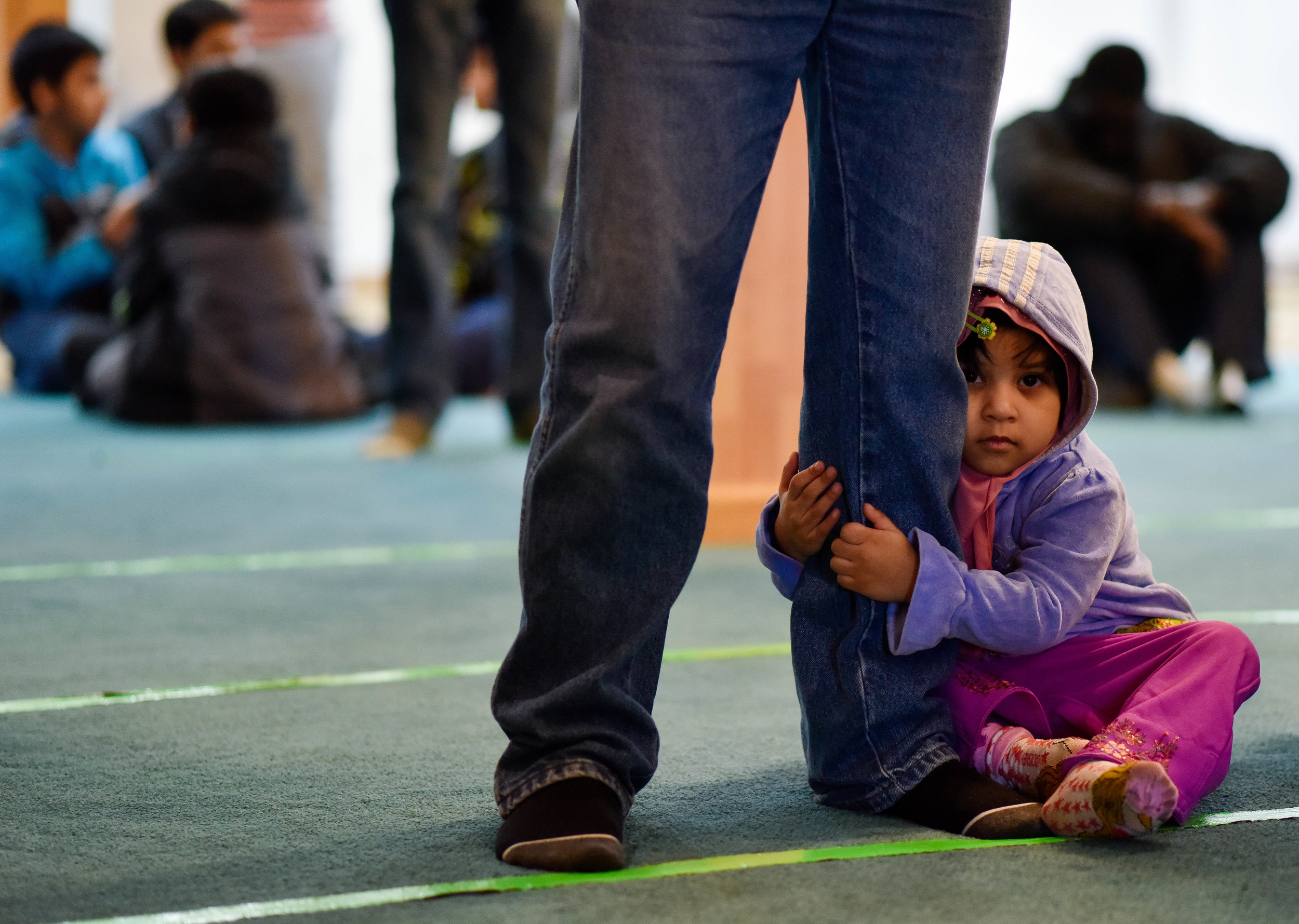 Maliha Uddin, 2, clings to her father Forkan’s leg before Friday afternoon service at Masjid Al-Noor. Forkan immigrated to the US from Bangladesh 30 years ago.