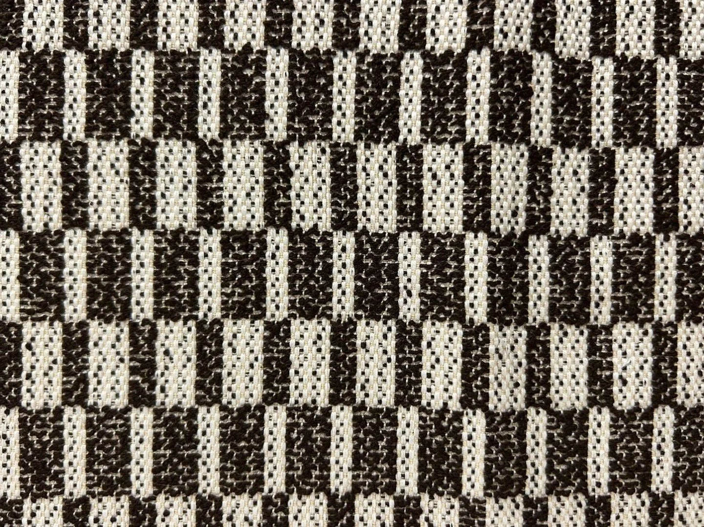 Block Weave Marrom from @tatizeasyliving combines rectangular blocks woven on a jacquard loom with dark brown original boucl&eacute; yarns, creating a rich and dynamic structure inspired by Native American blankets and rugs. Its texture evokes the ha