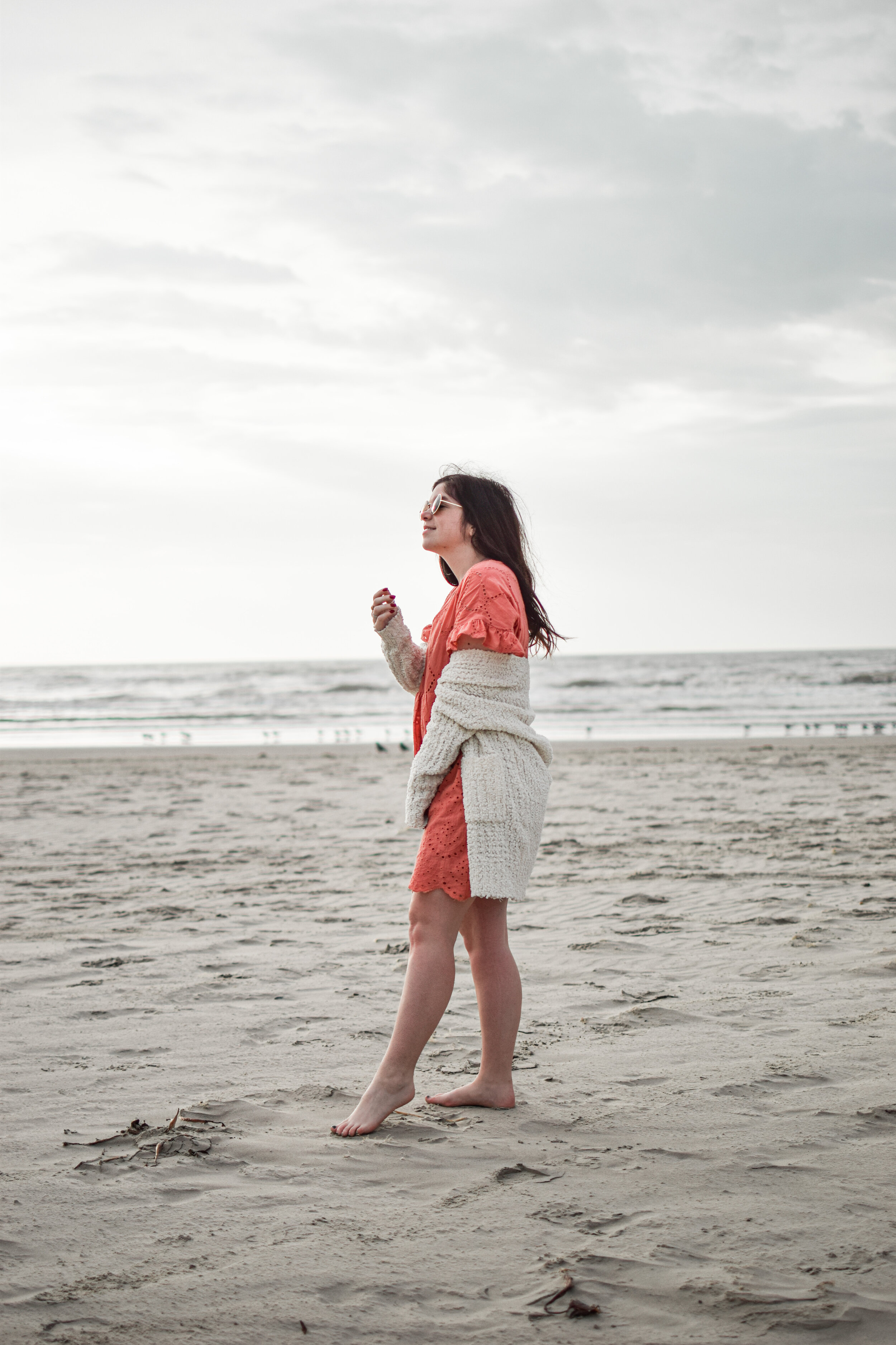 woman at the beach wearing dress and sweater