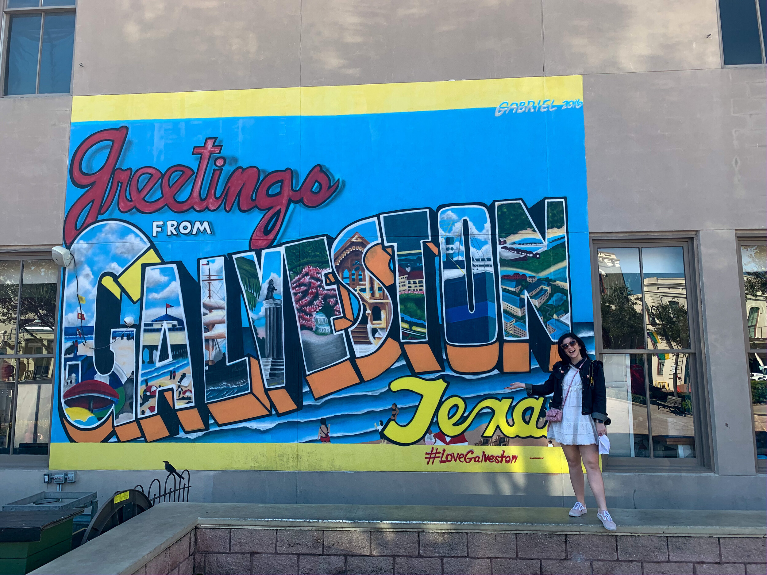 woman taking a photo with a Galveston mural