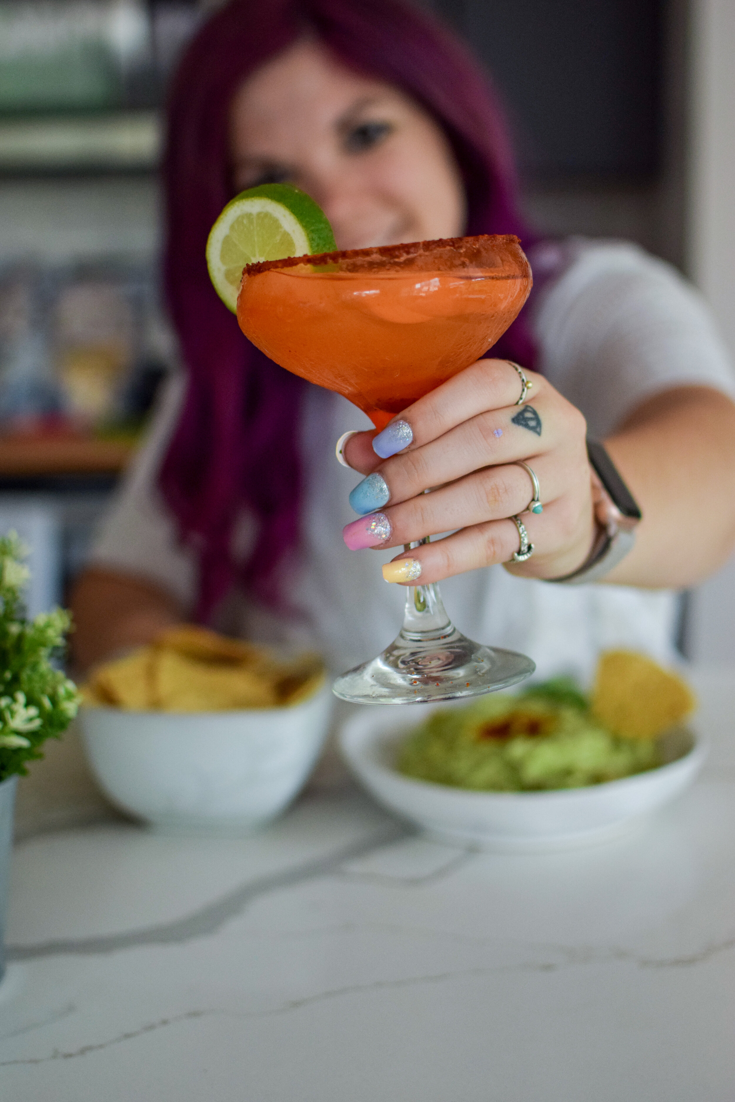 woman holding a glass of jalpeno margaritas 