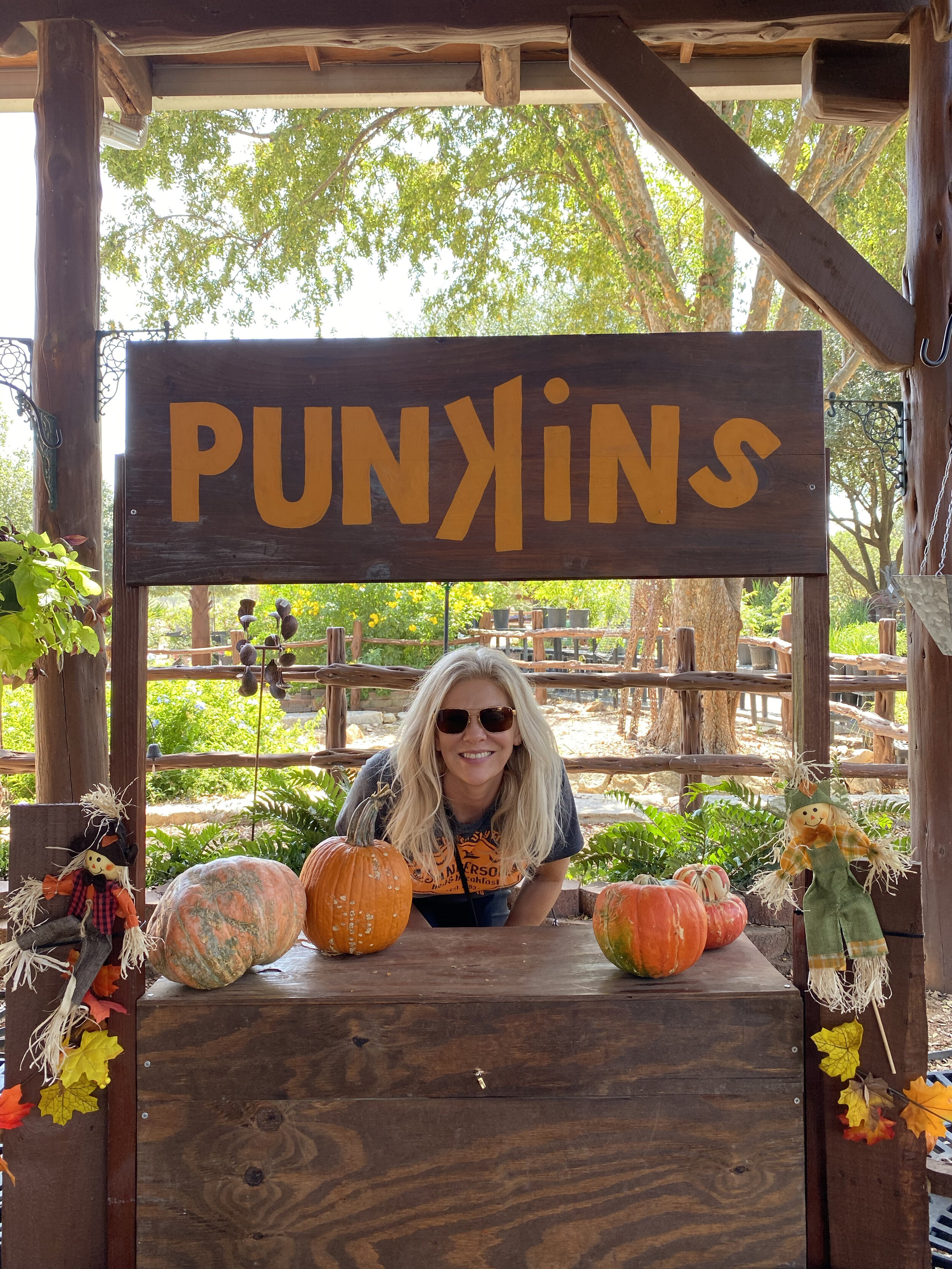 woman taking a photo at the pumpkin stand 
