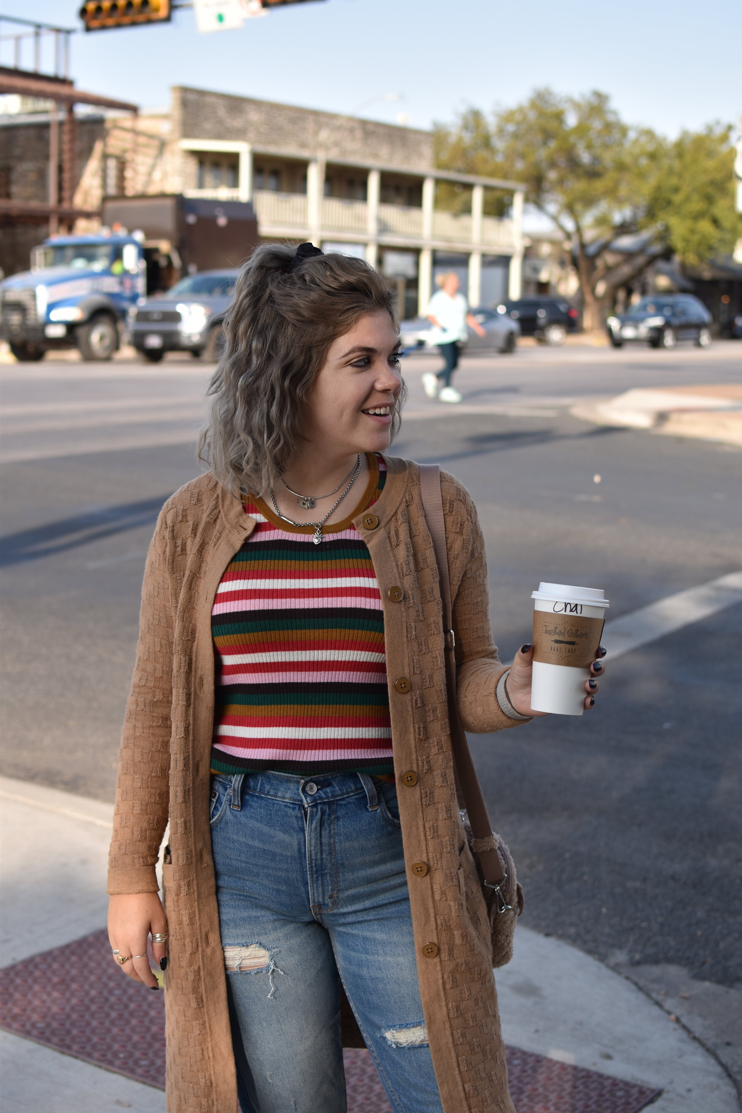 woman holding a coffee to-go on the streets of Fredericksburg
