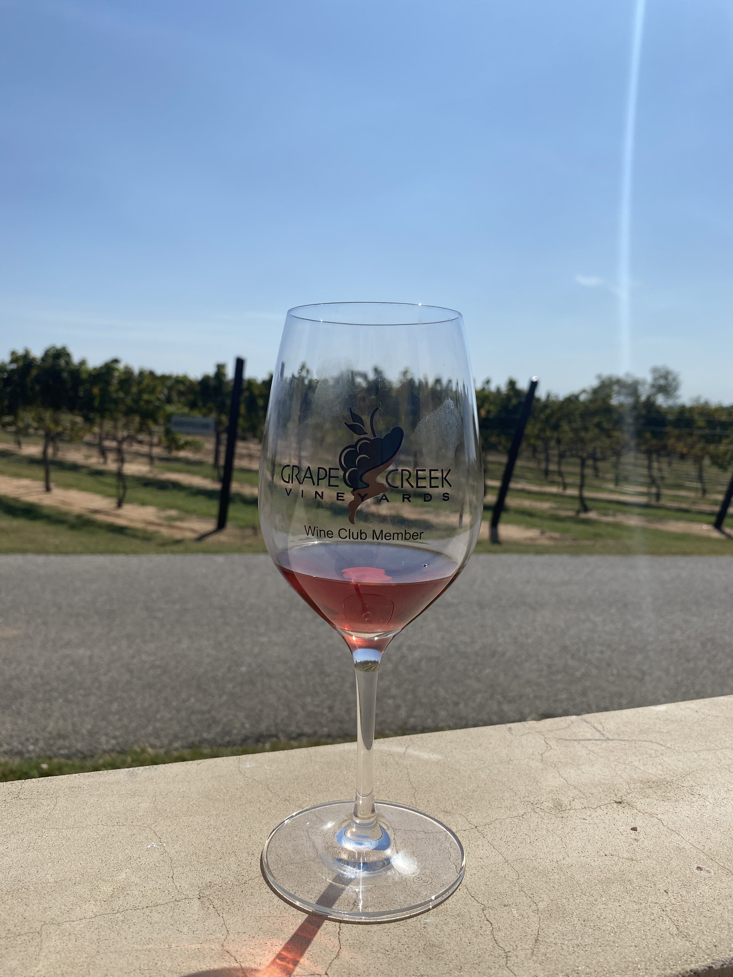 a wine glass with the Grape Creek Vineyards on the background