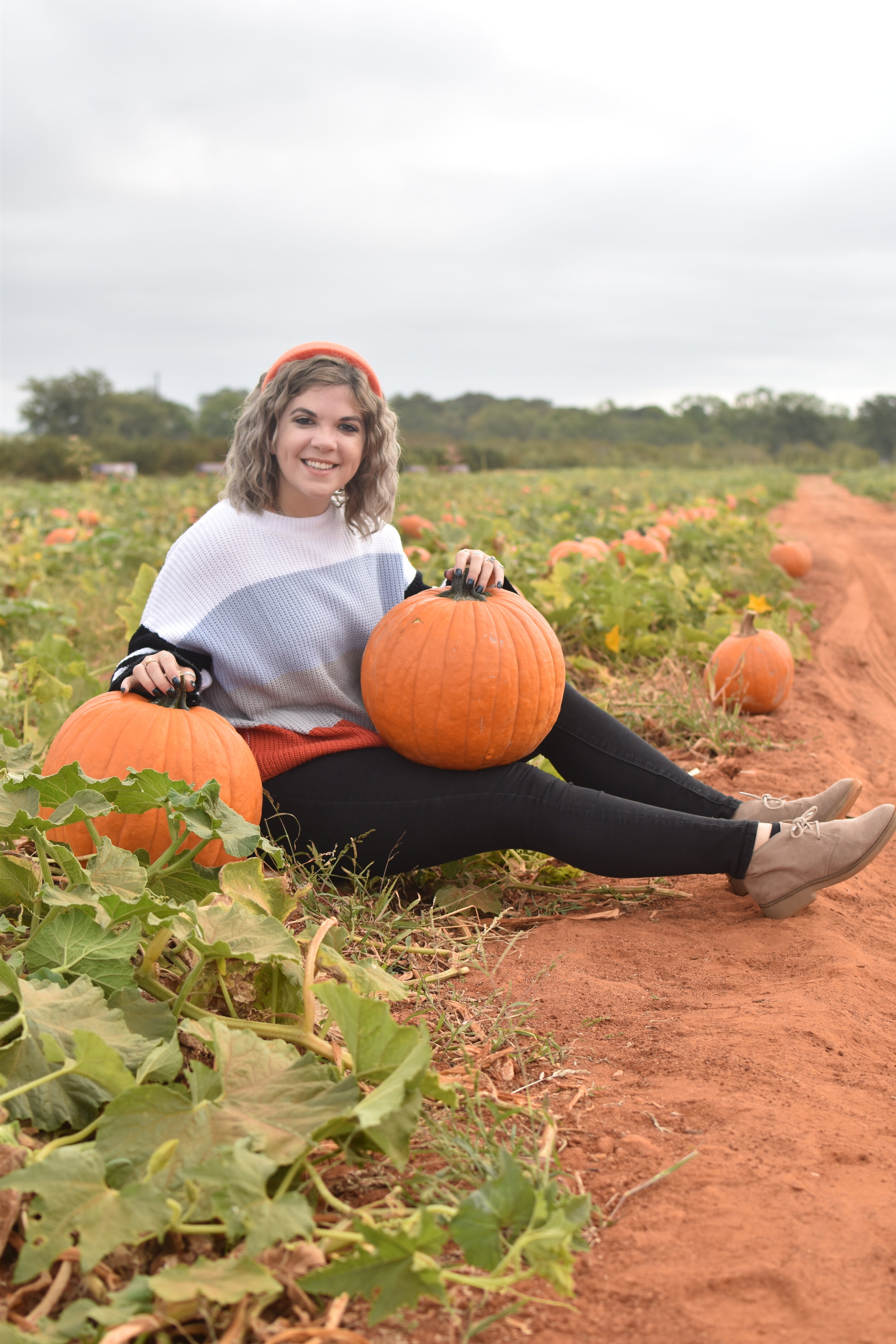 woman sitting on the ground with pumpkins at the Jenschke Orchards