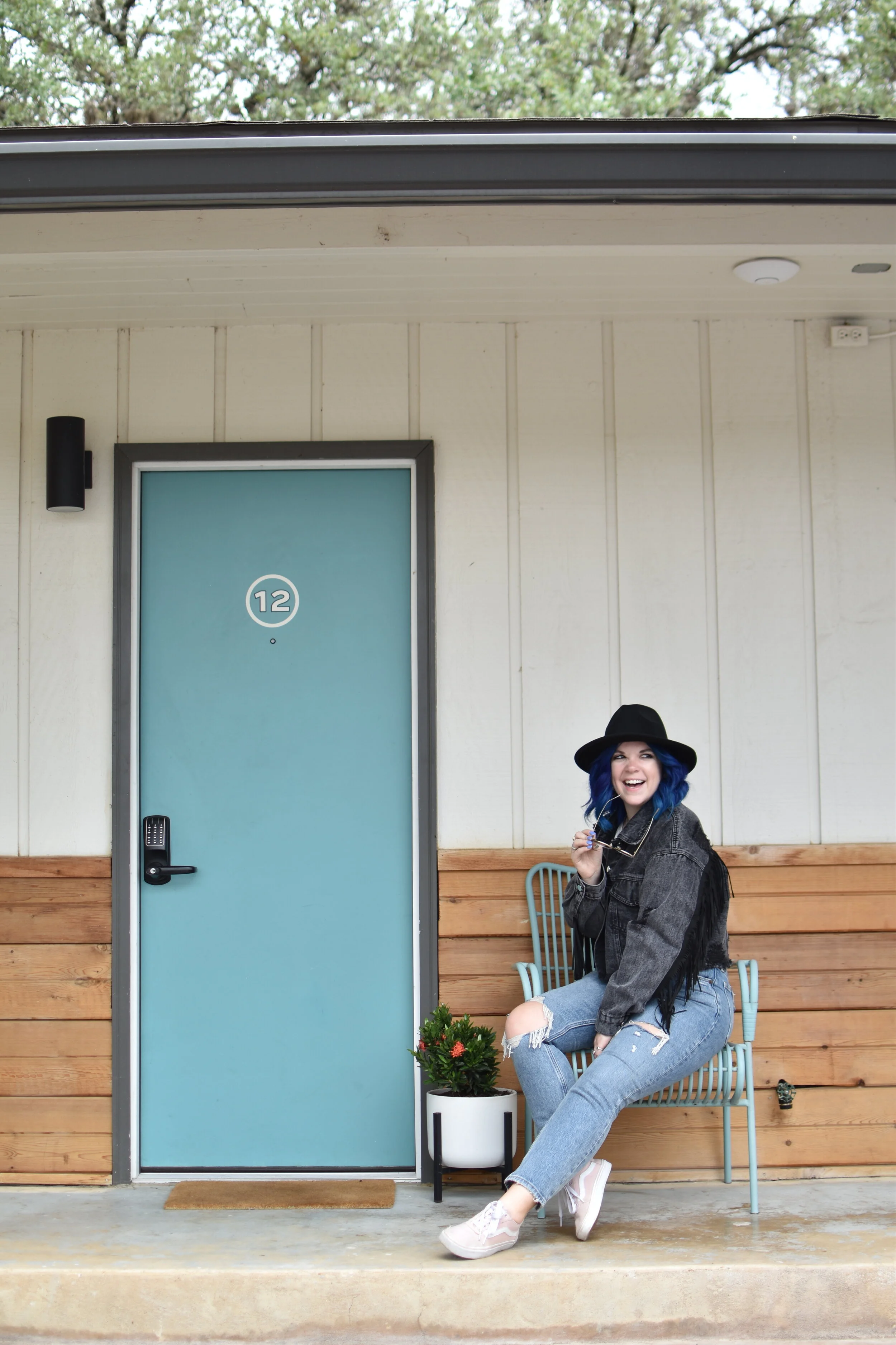 woman sitting outside her room at STONEWALL MOTOR LODGE