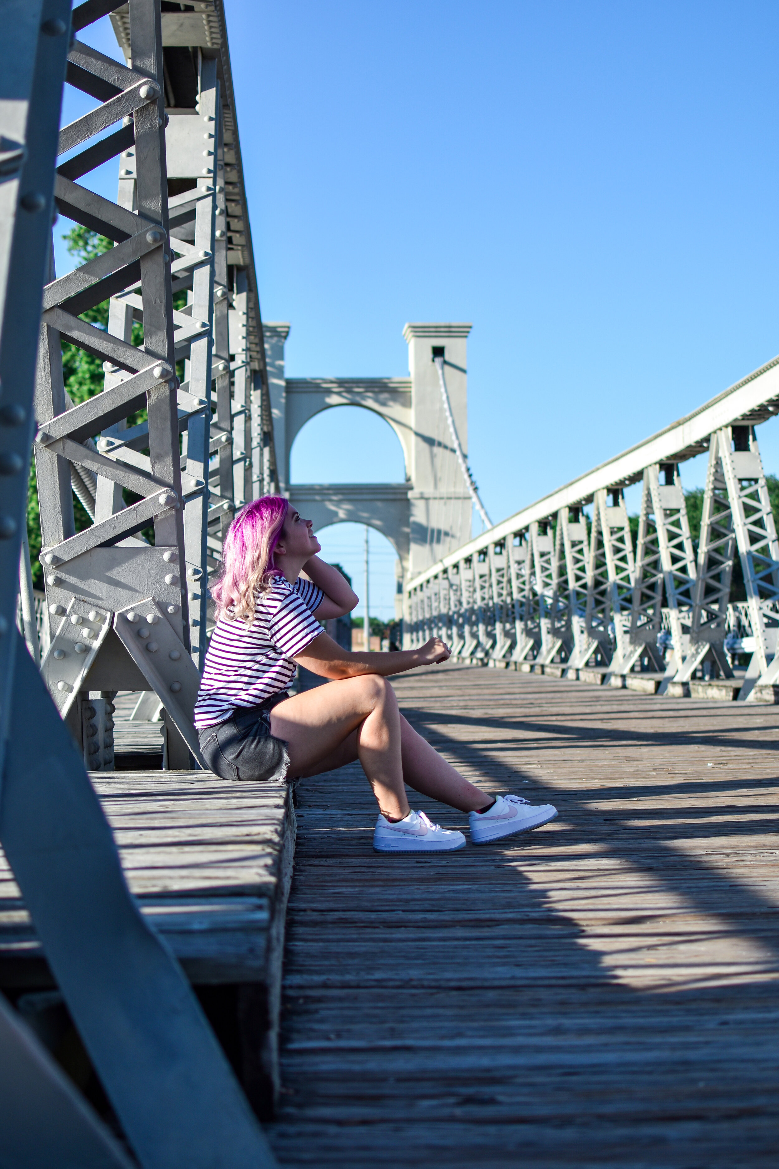 woman sitting at the  Waco Suspension Bridge