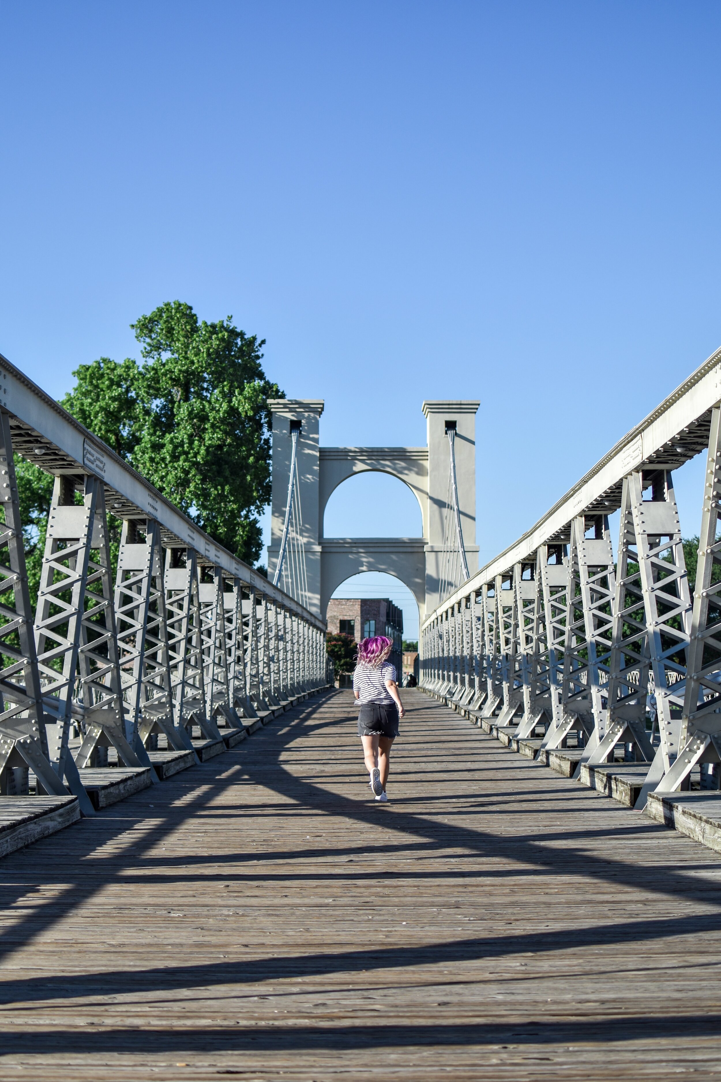 woman walking at the  Waco Suspension Bridge