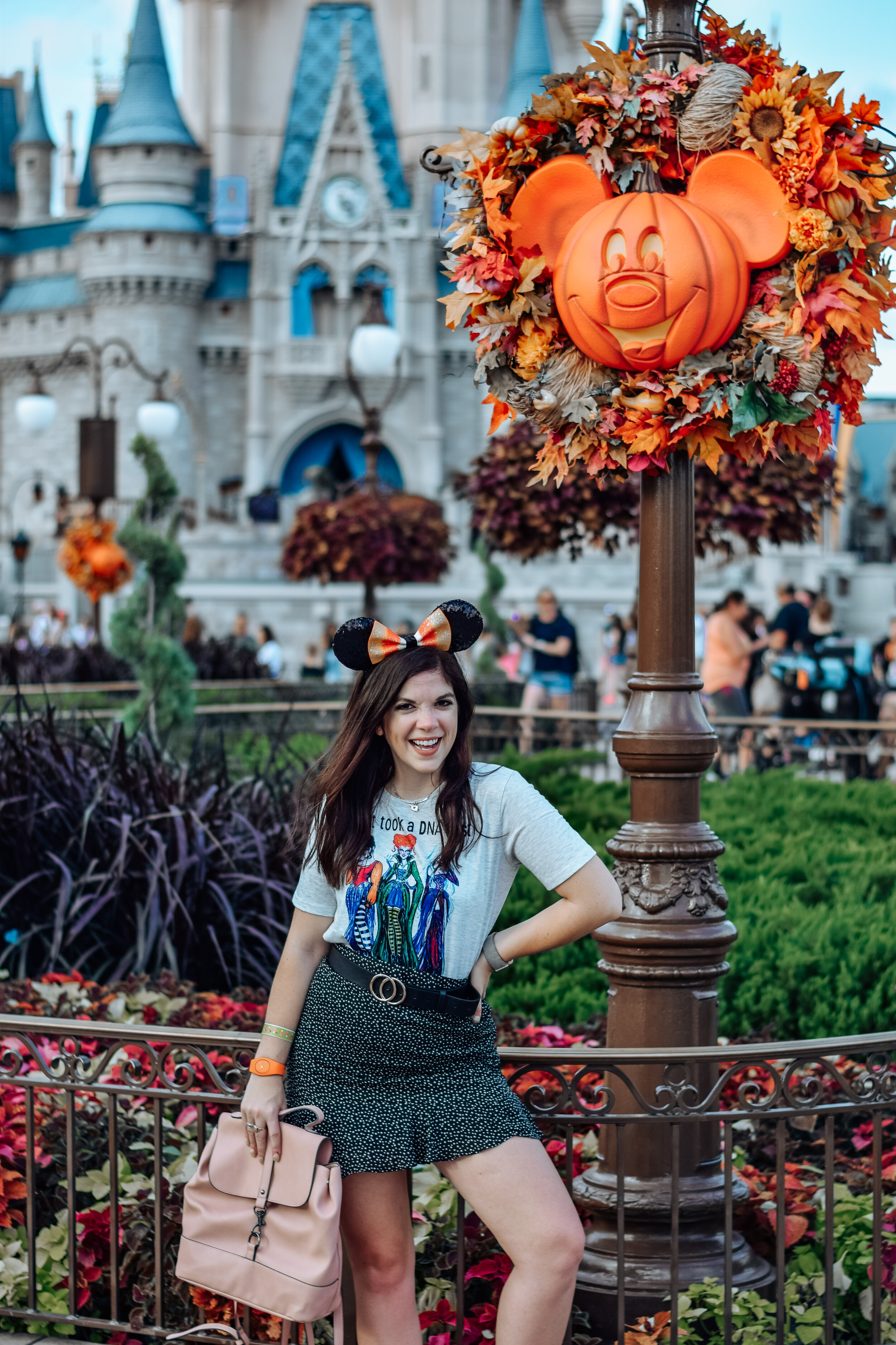 woman holding a bag, wearing white shirt and skirt celebrating Halloween at Disney World