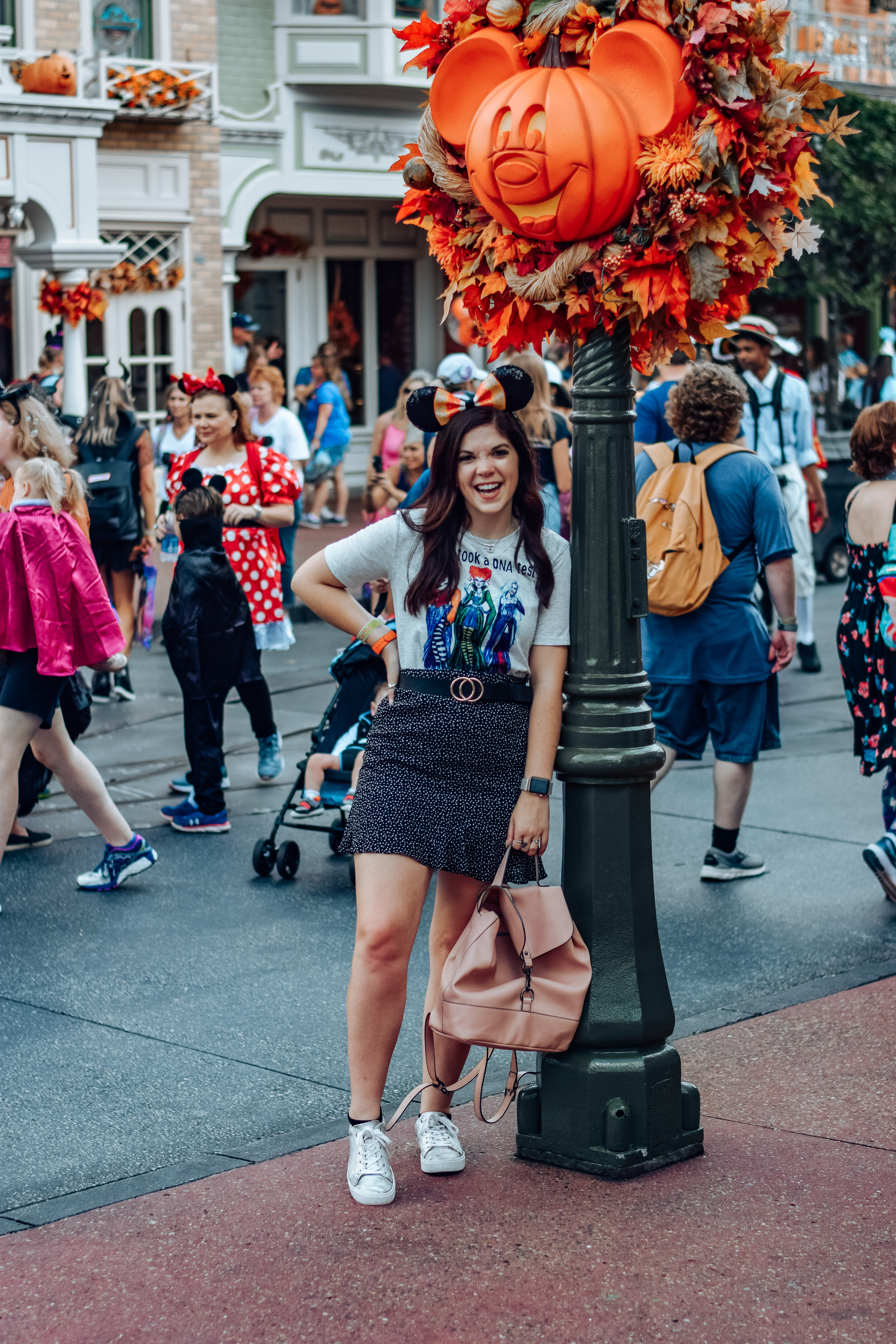 woman leaning on a pole at disney celebrating Halloween at Disney World