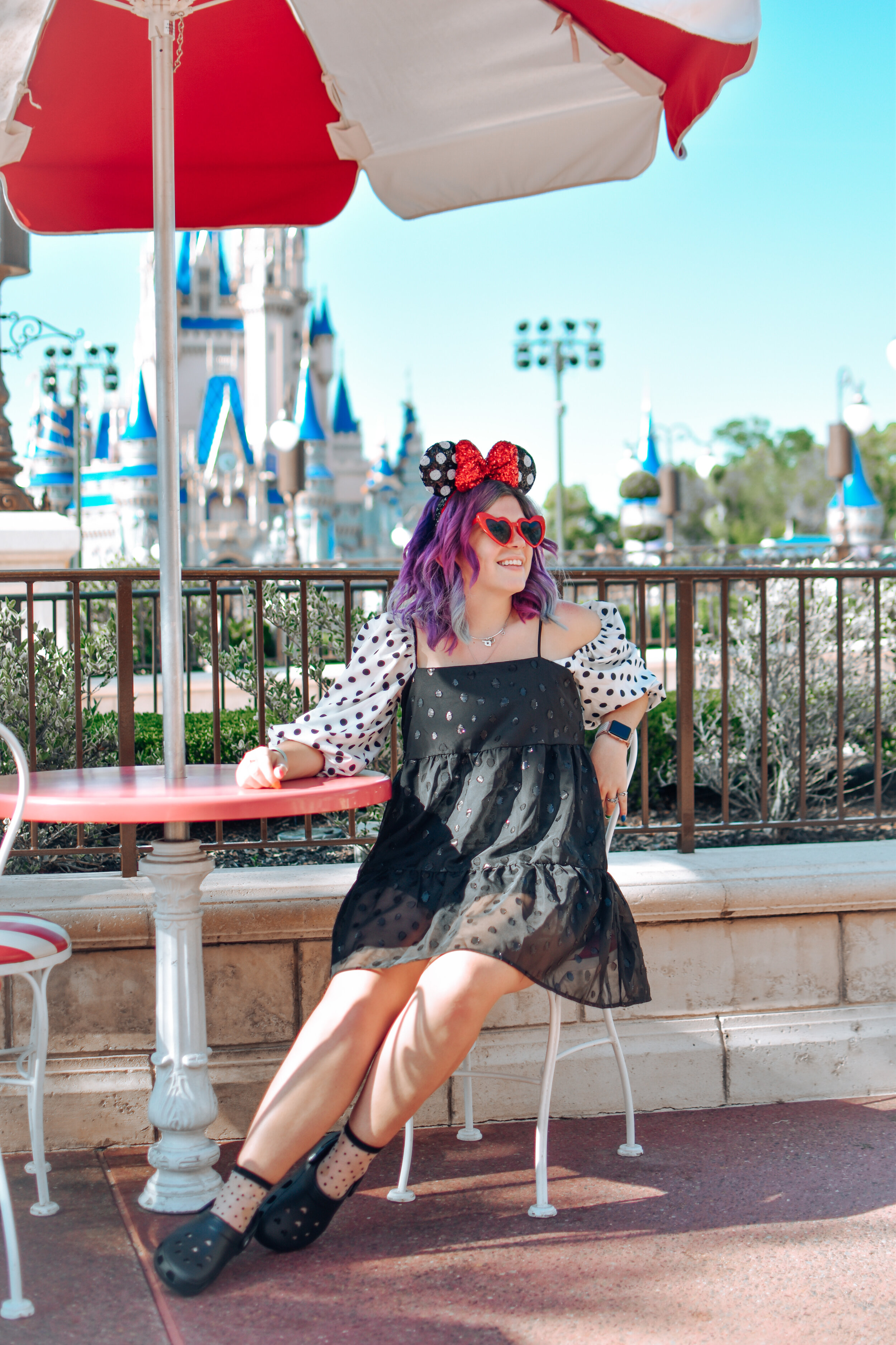 woman with purple hair and wearing outfits for disney park