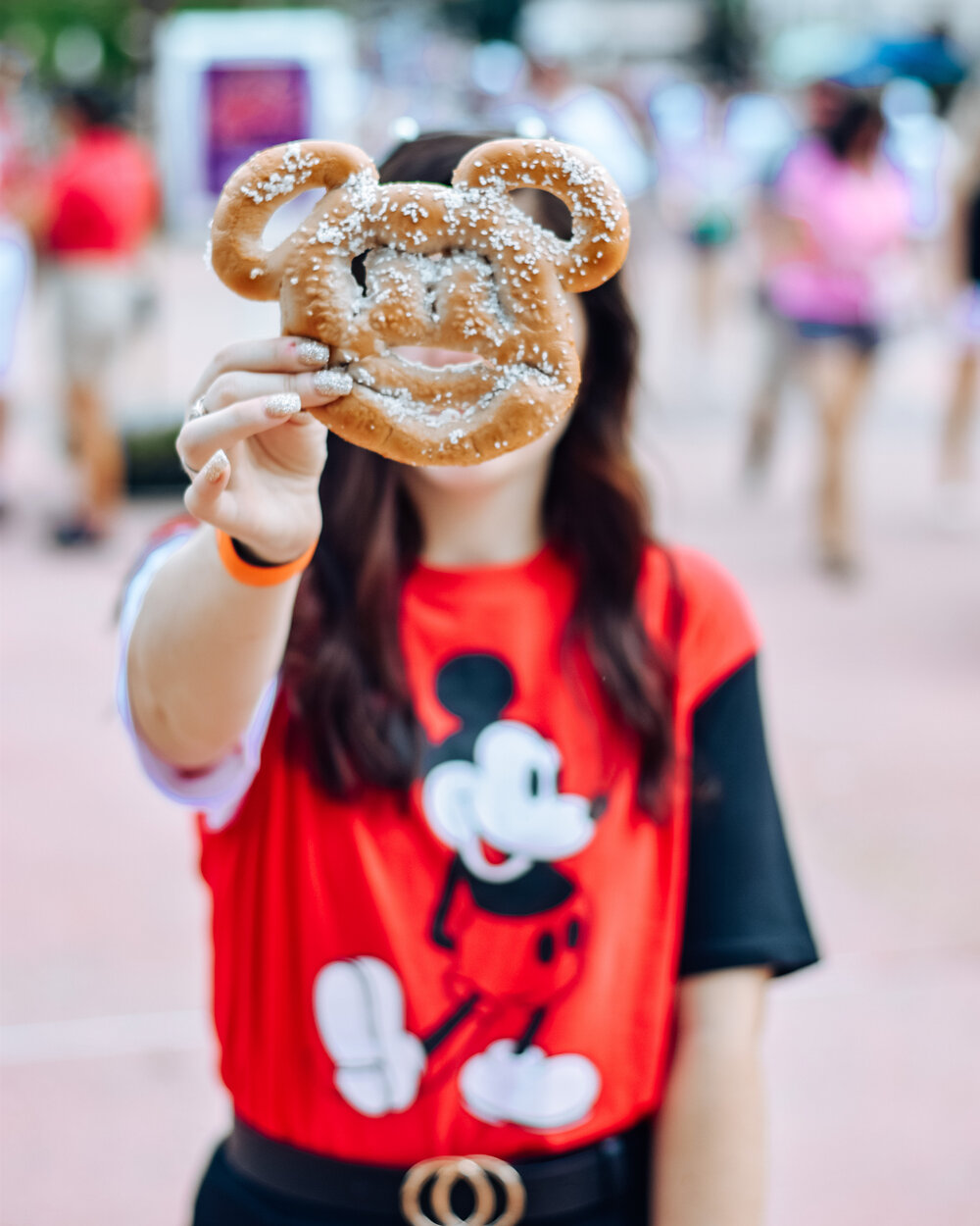 woman holding bread and wearing outfits for disney park