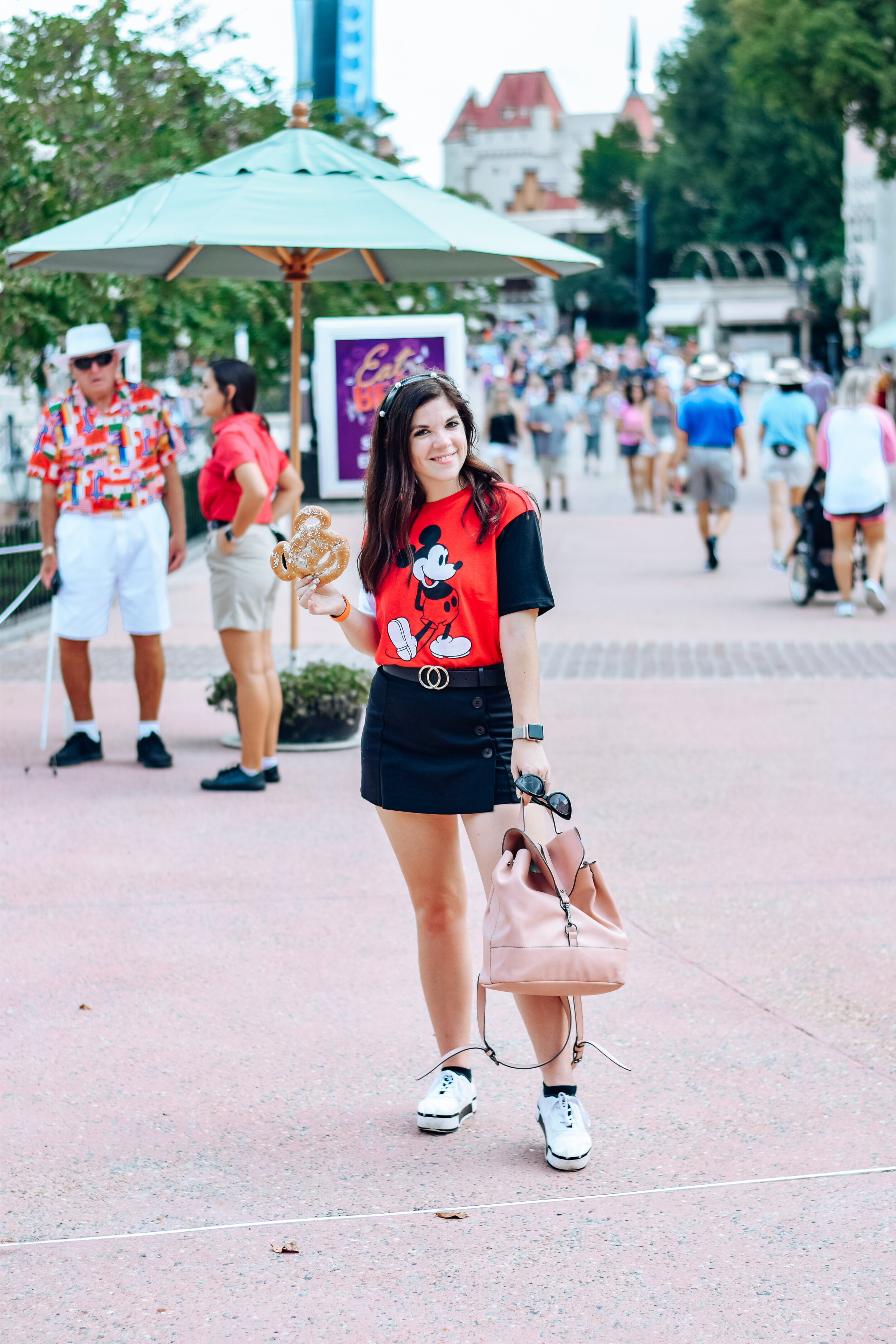 woman holding bread and sharing outfits for disney park