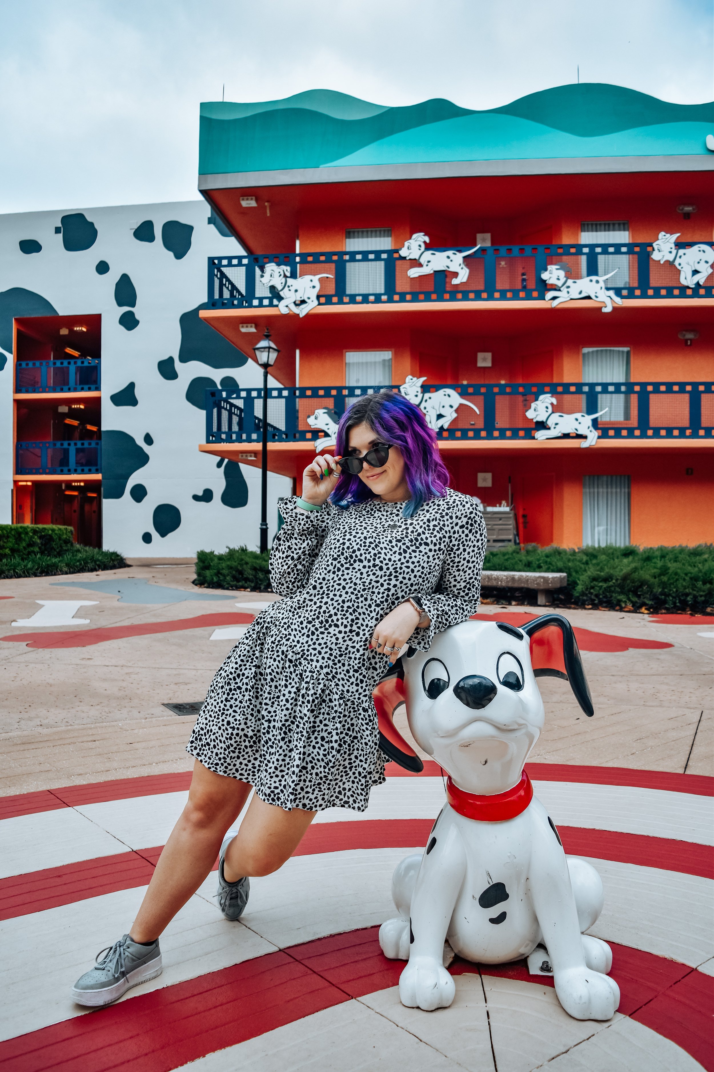 woman leaning at a dog statue at disney's all-star movies resort