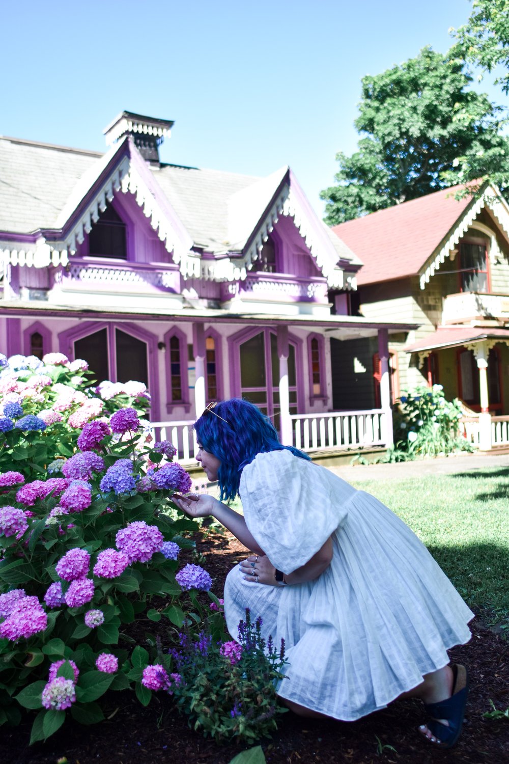 woman smelling the flowers outside GINGERBREAD VILLAGE