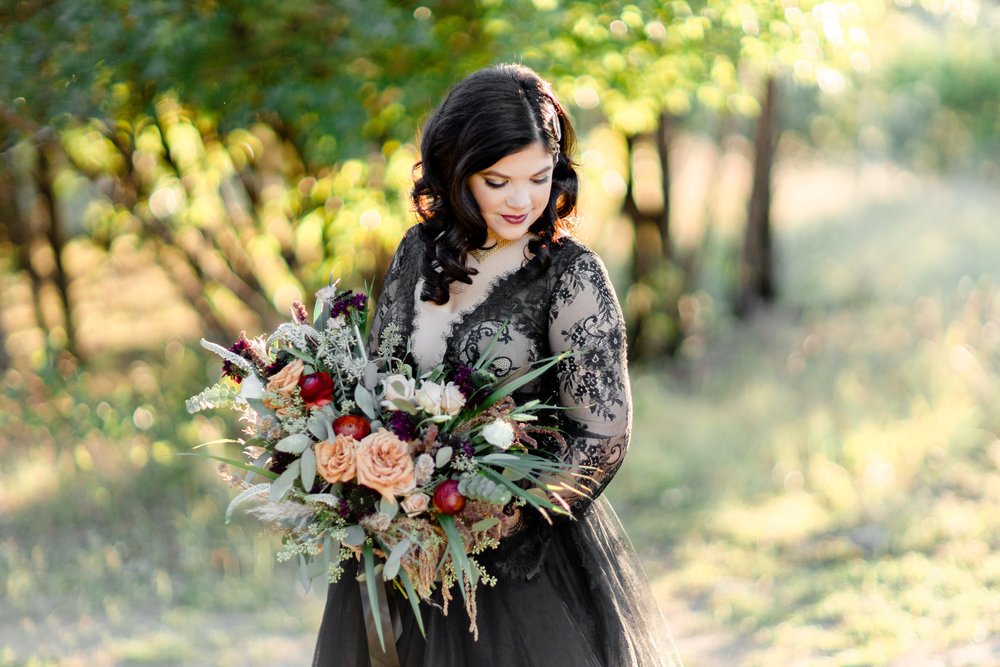 woman in black wedding  dress and holding her bouquet for fall wedding