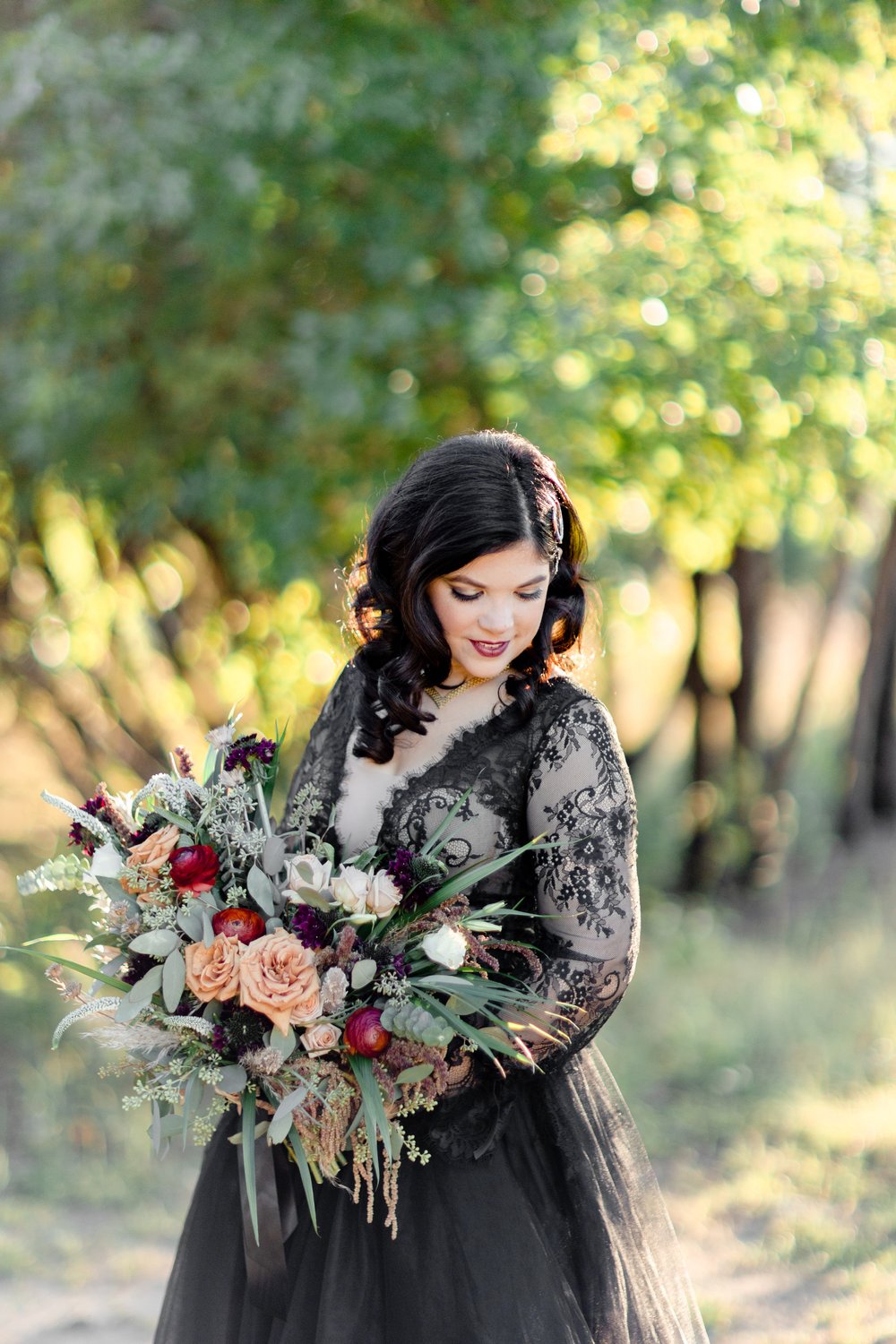 woman wearing black wedding  dress and holding her bouquet for fall wedding
