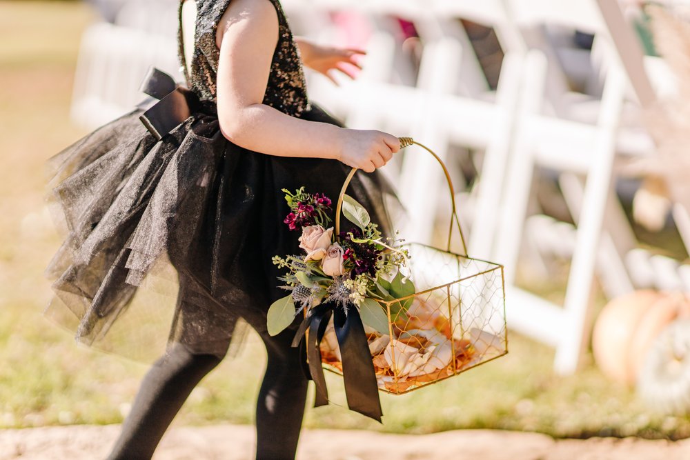 flower girl holding a basket of flowers for fall wedding 