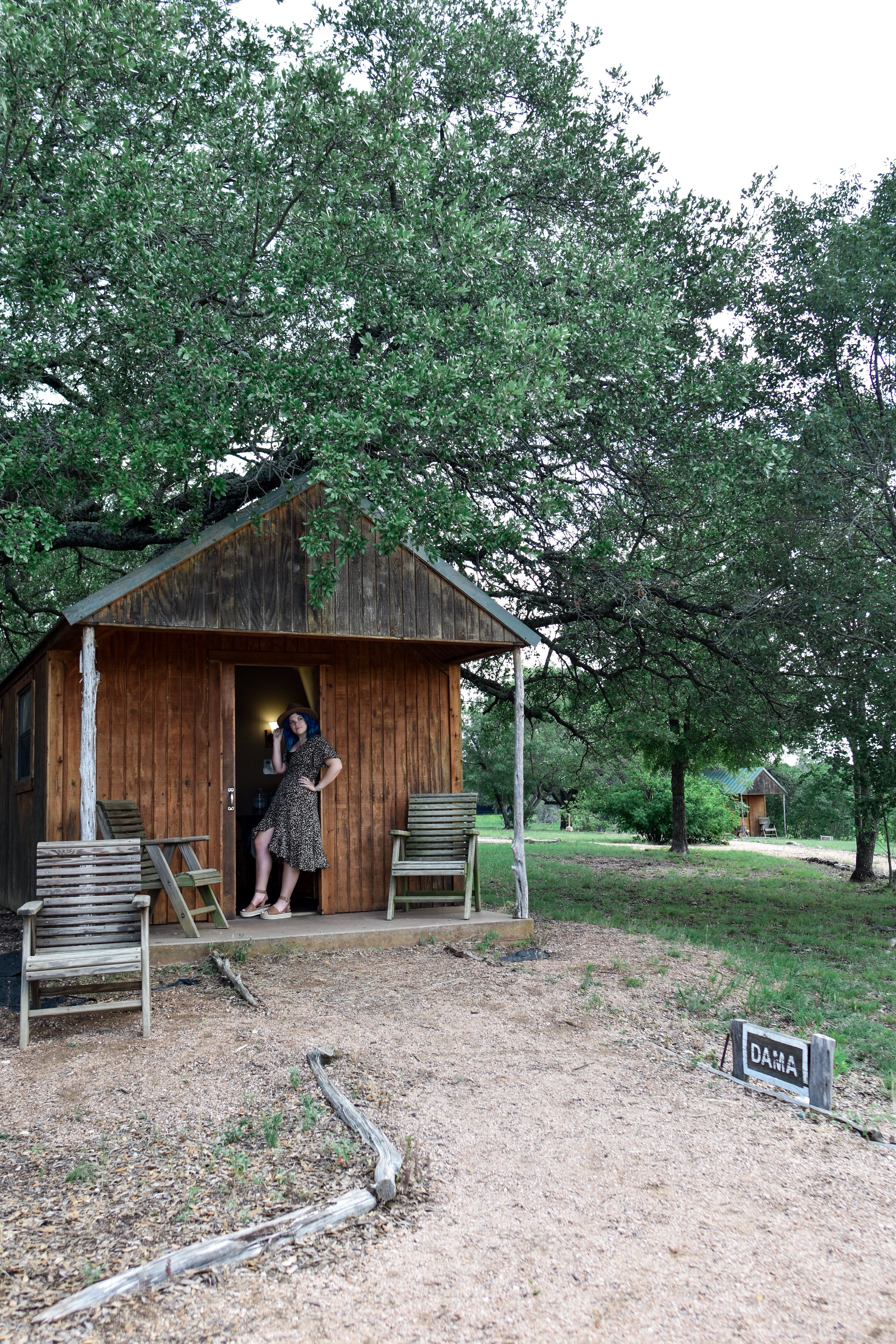 woman standing outside the room of THE FOOTHILLS SAFARI CAMP in one of the places to stay in glen rose tx