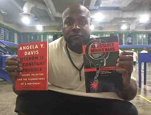 Khalfani with books by Angela Davis and Victoria Law