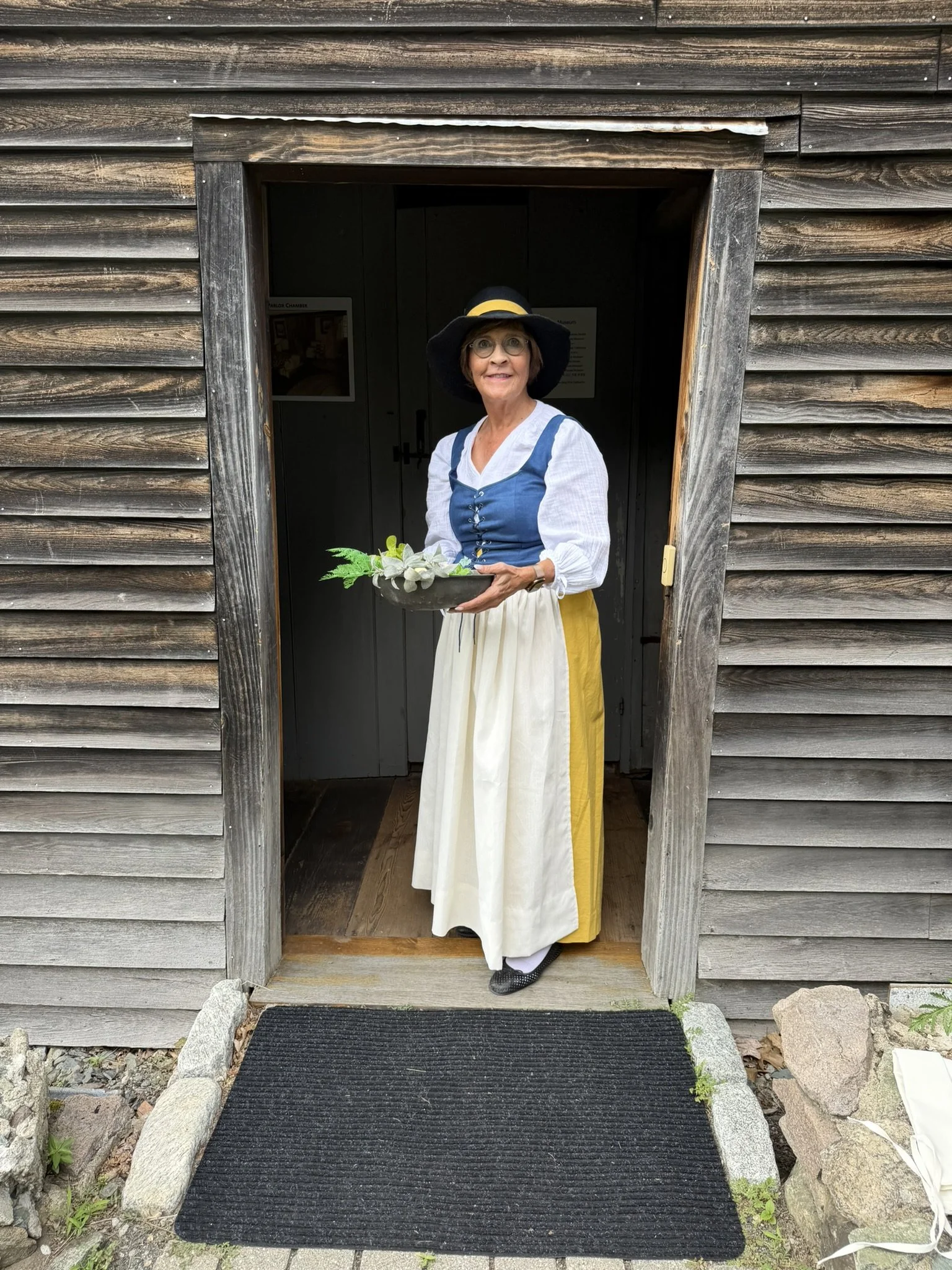 Sharmin Fairbanks McKenny dressed in 1600s costume at front door of Fairbanks House in Dedham, MA