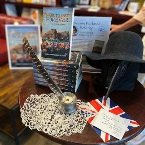 Display of book Made to Last Forever with pewter inkwell, glasses, doily, quil, 1600s physician's mask 1600s letter and sample of British flag