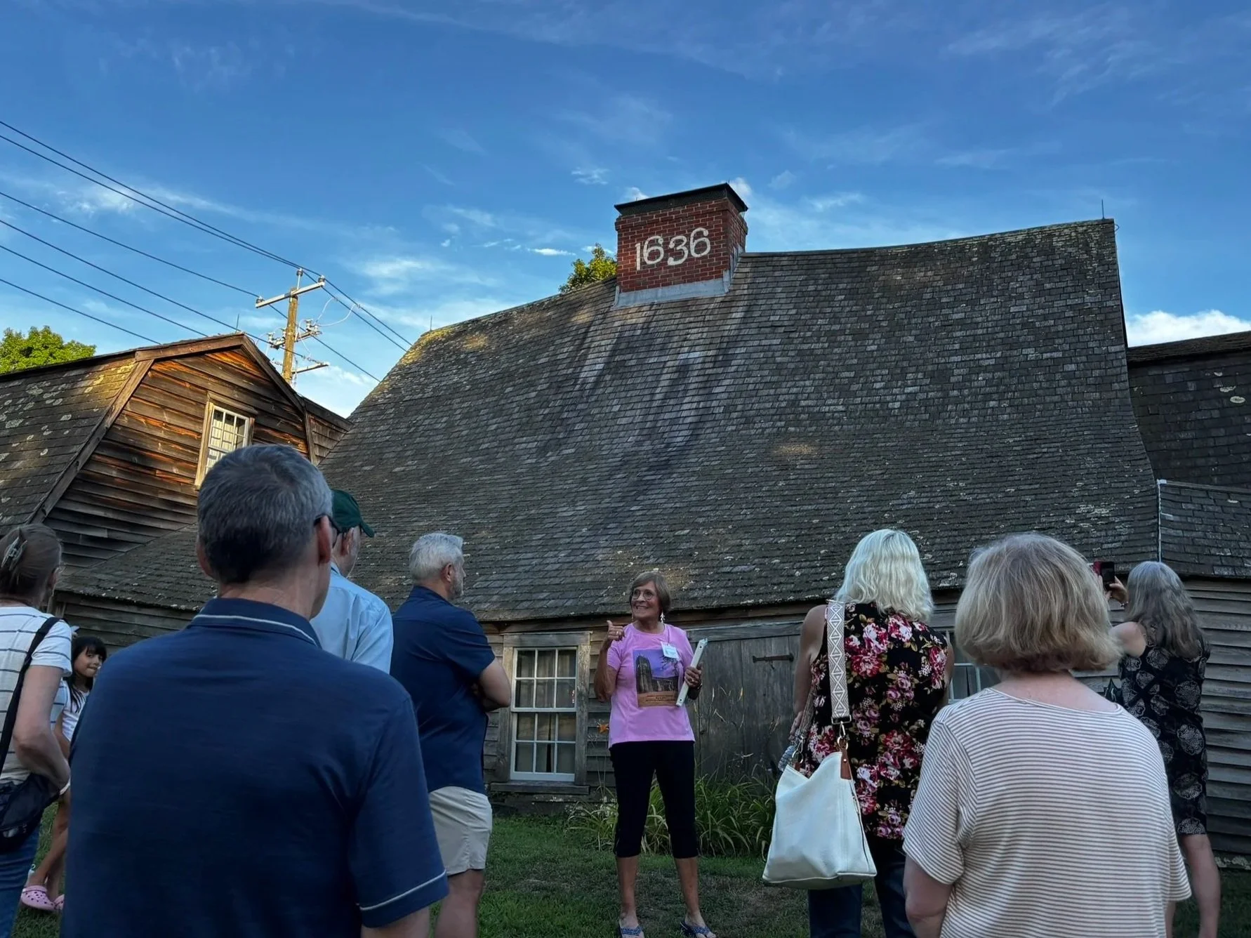 Group listening to Sharmin Fairbanks McKenny as she discusses original settlers who built the Fairbanks House