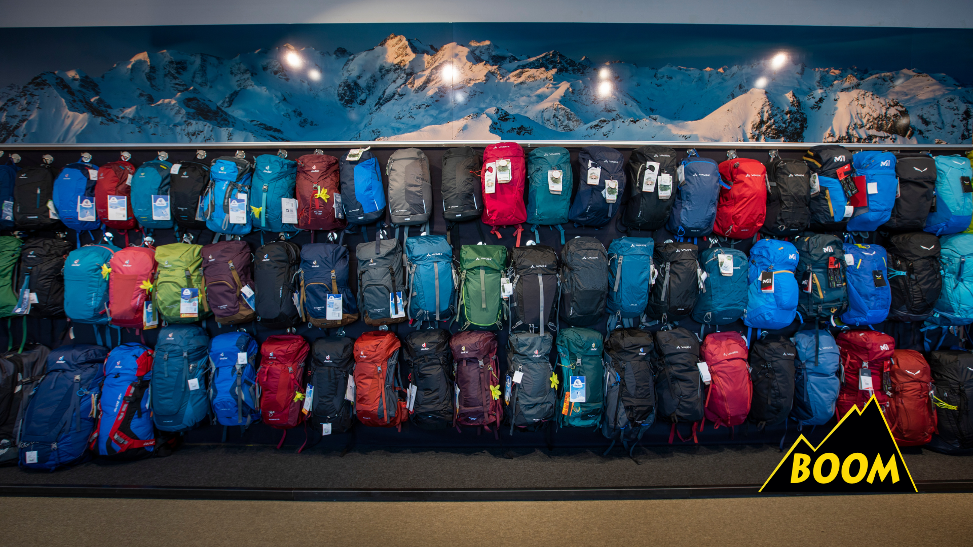 Auswahl an Outdoor- und Sportrucksäcken im Sportgeschäft von Boom Sport in St. Moritz mit Bergmotiv im Hintergrund.