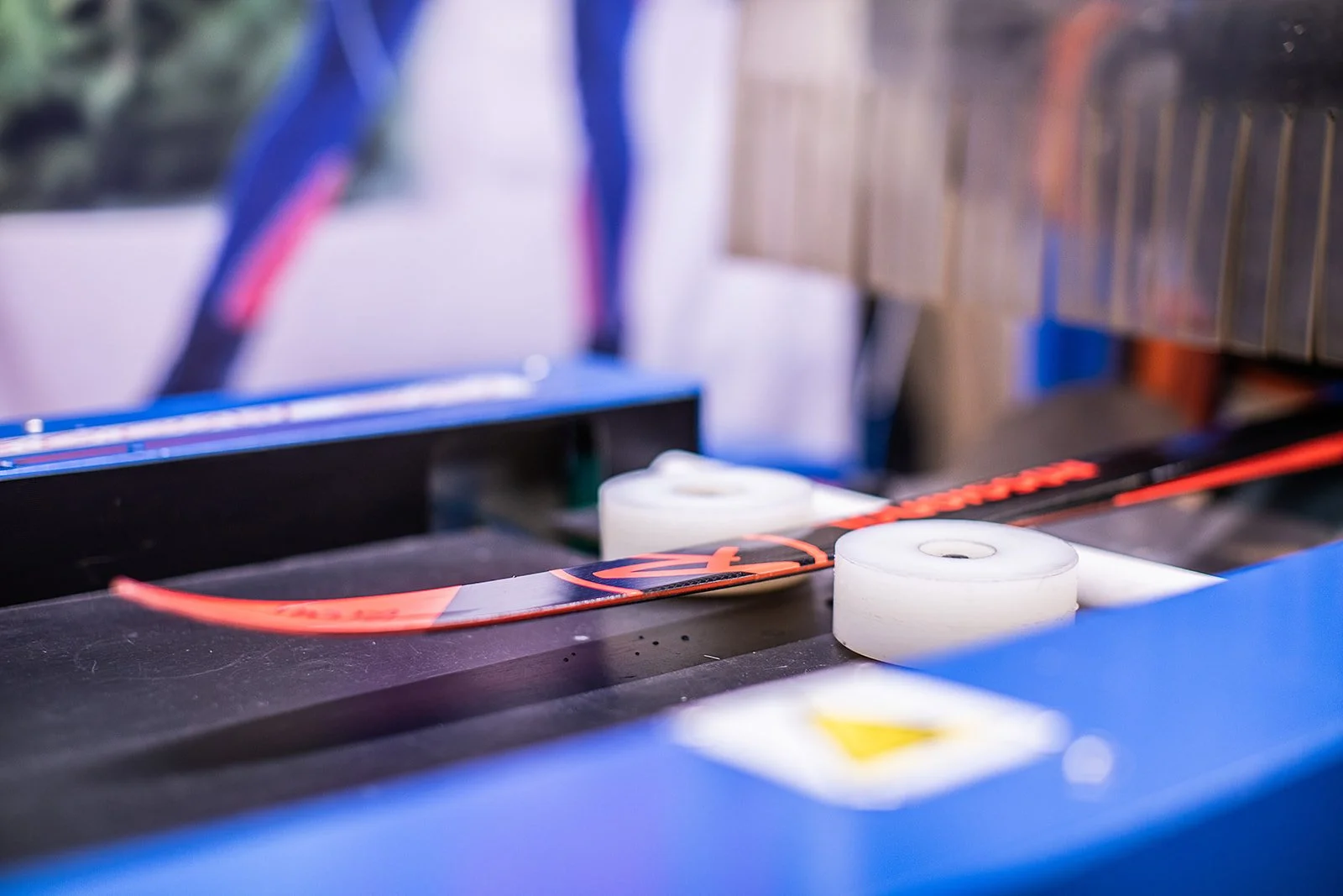 Sports rail on a conveyor belt or machine in a store or production facility, with white rollers and a red stripe