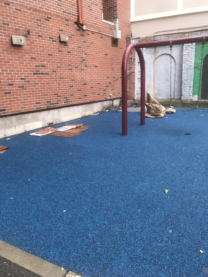 trash and cardboard littering the childrens playground at cutillo park