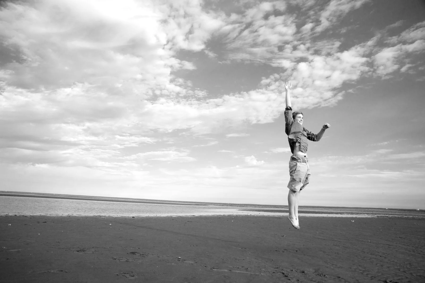Teenager jumping at Family photo session on Old Mill beach in Westport, CT