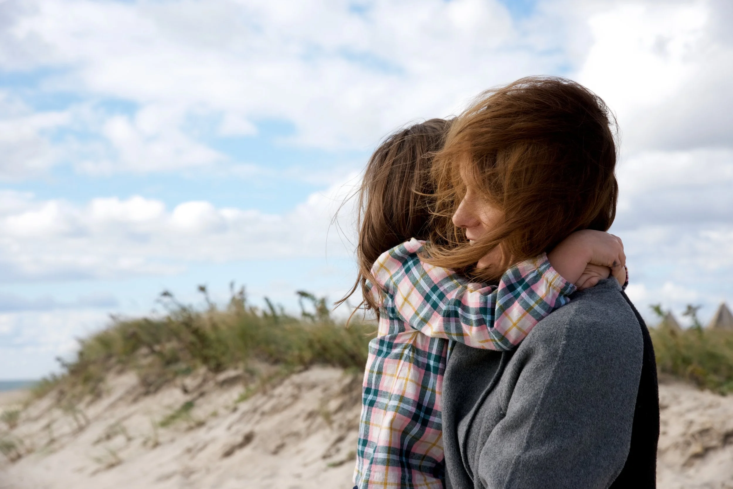 Mom hugs her child on the dunes in the Hamptons, by lifestyle photographer Pamela Einarsen. 