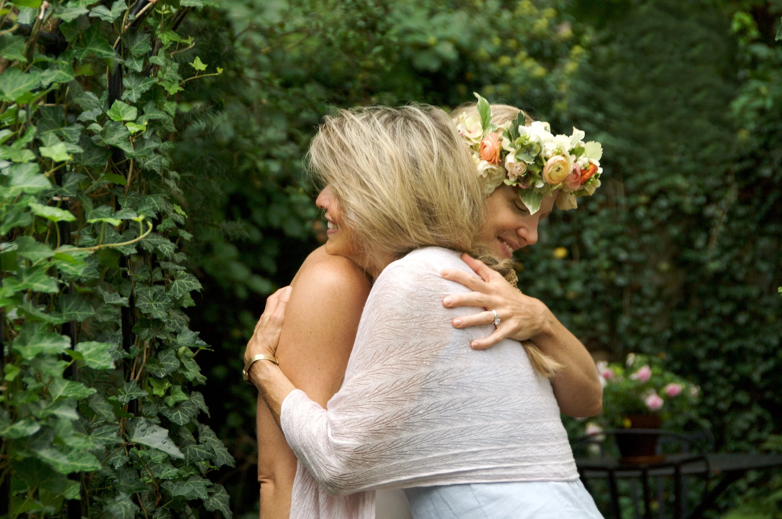 Bride hugs mother at outdoor wedding by candid photographer Pamela Einarsen.