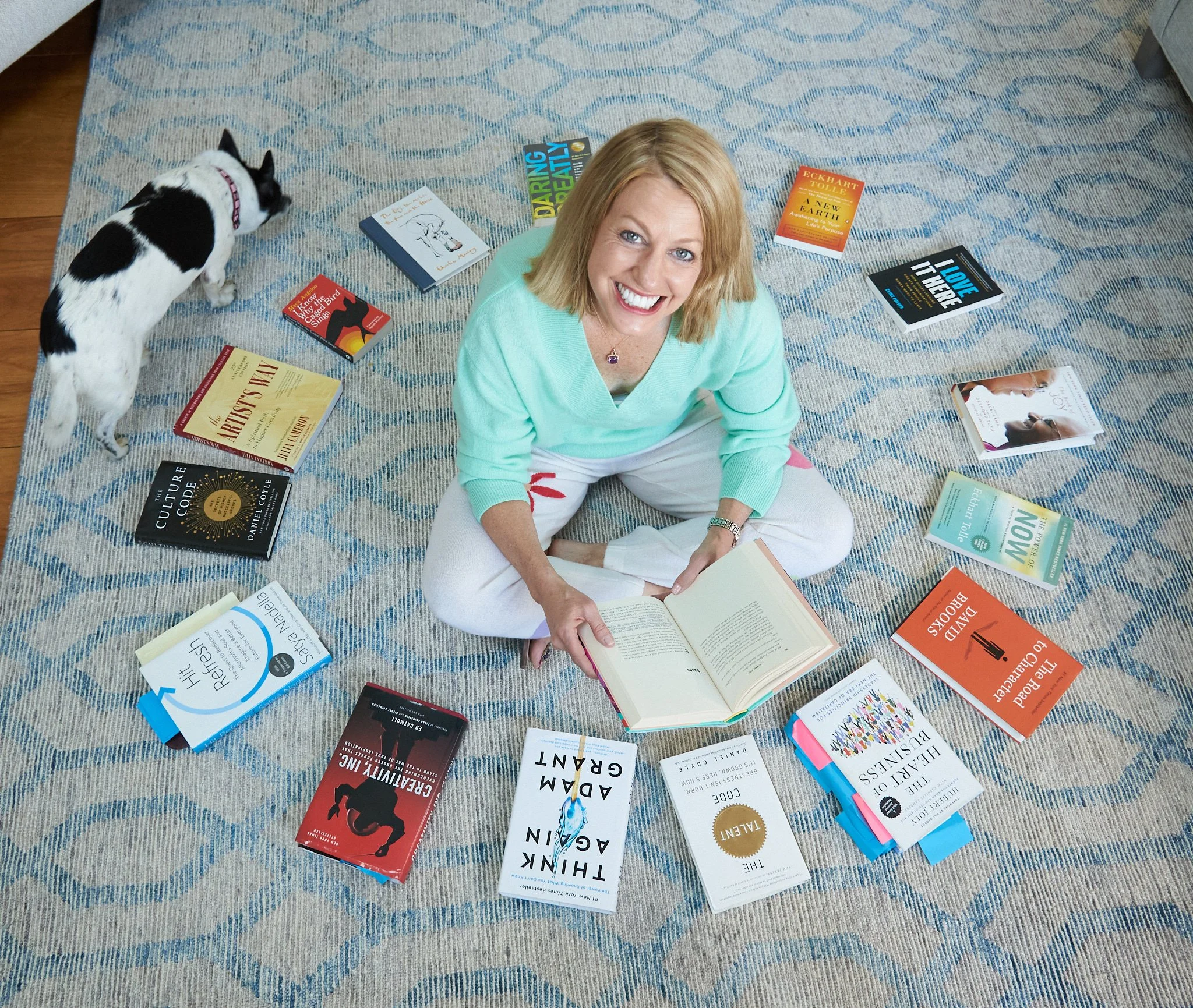 Woman surrounded by her books in a personal branding session at her Ridgefield home with photographer Pamela Einarsen. 
