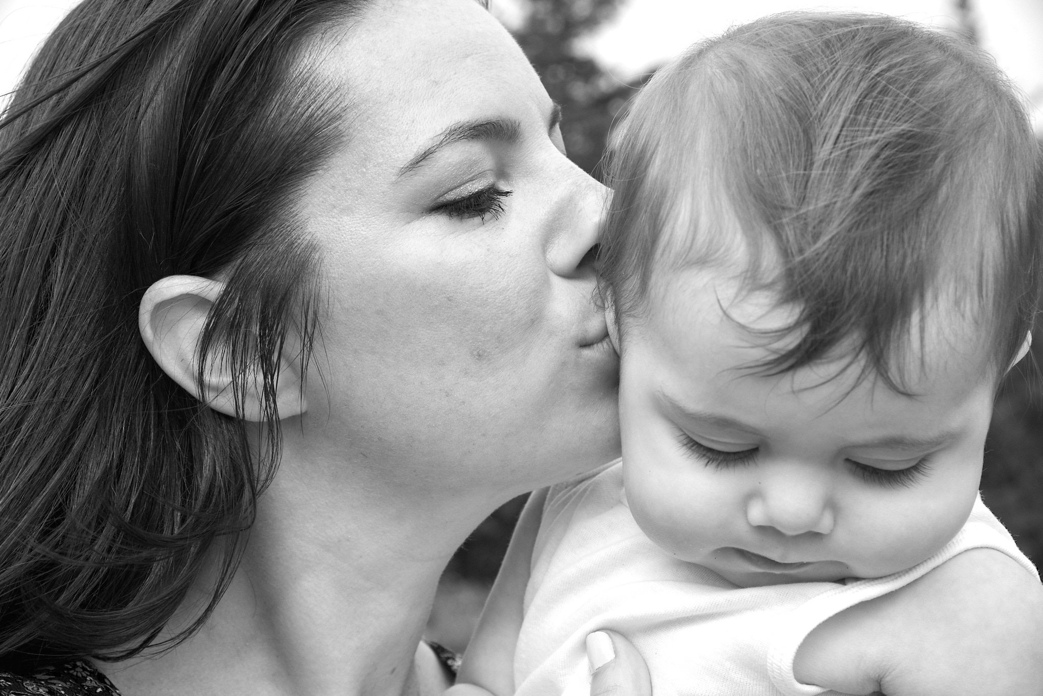 B&amp;W portrait of Greenwich , CT mom kissing daughter by portrait photographer Pamela Einarsen. 