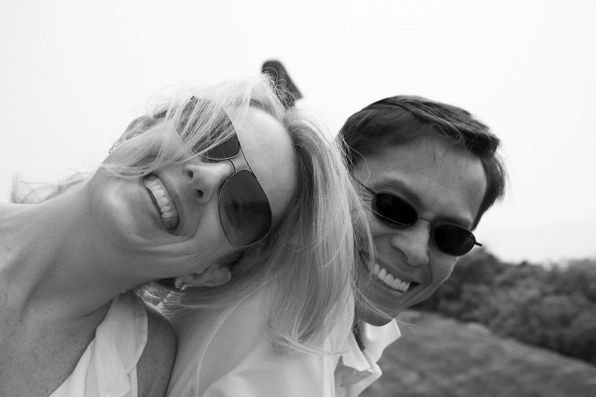 Husband and wife laugh on a Narragansett beach in B&amp;W portrait by Pamela Einarsen. 