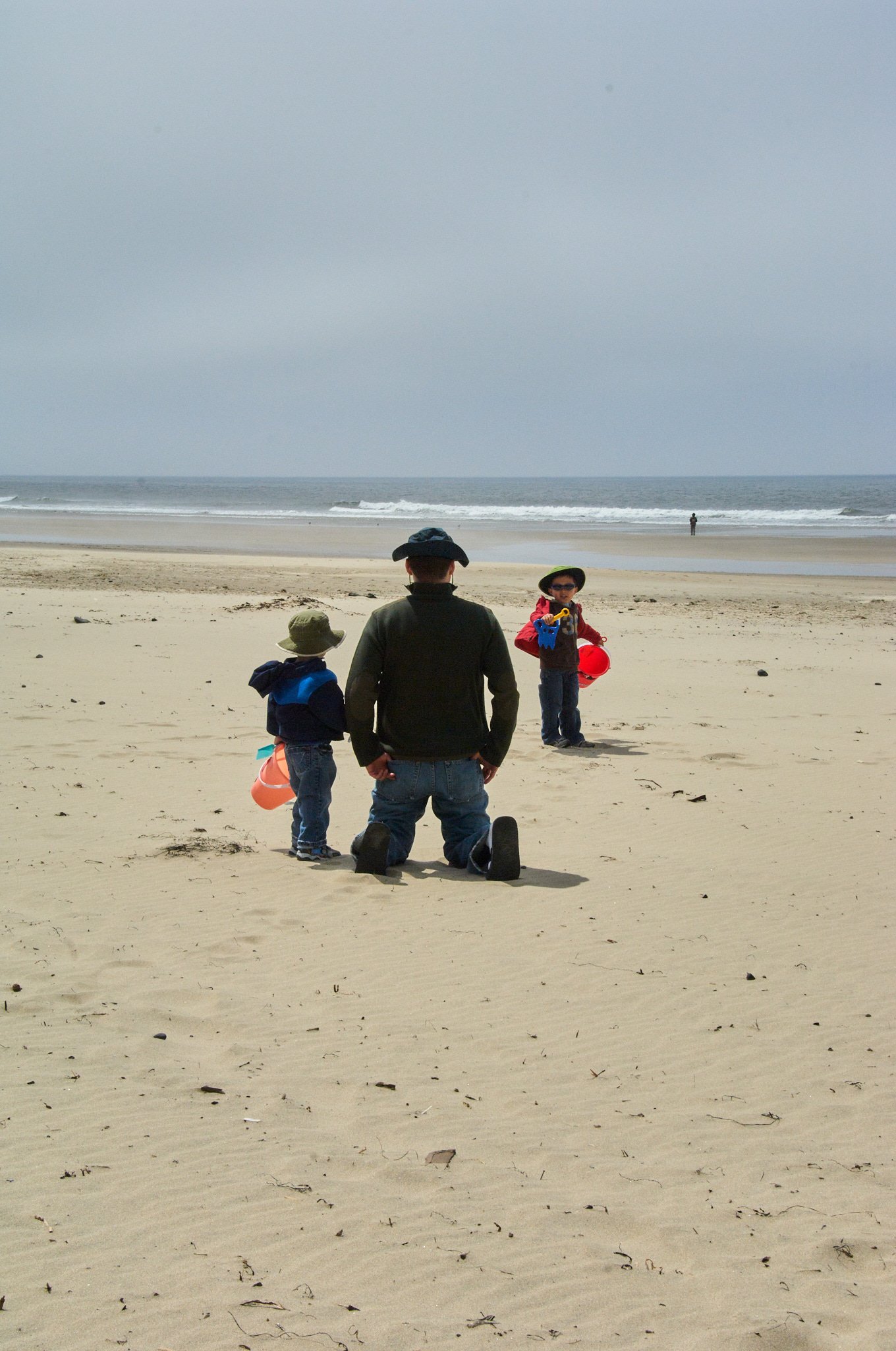 Father plays with sons on the Oregon coast at a family session with photographer Pamela Einarsen.