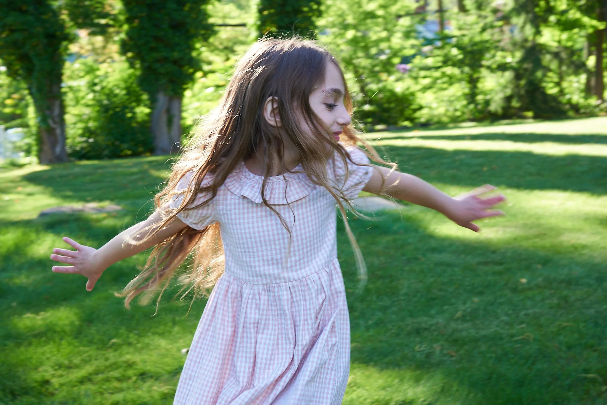 Girl twirls in Wilton, CT backyard with family photographer Pamela Einarsen. 