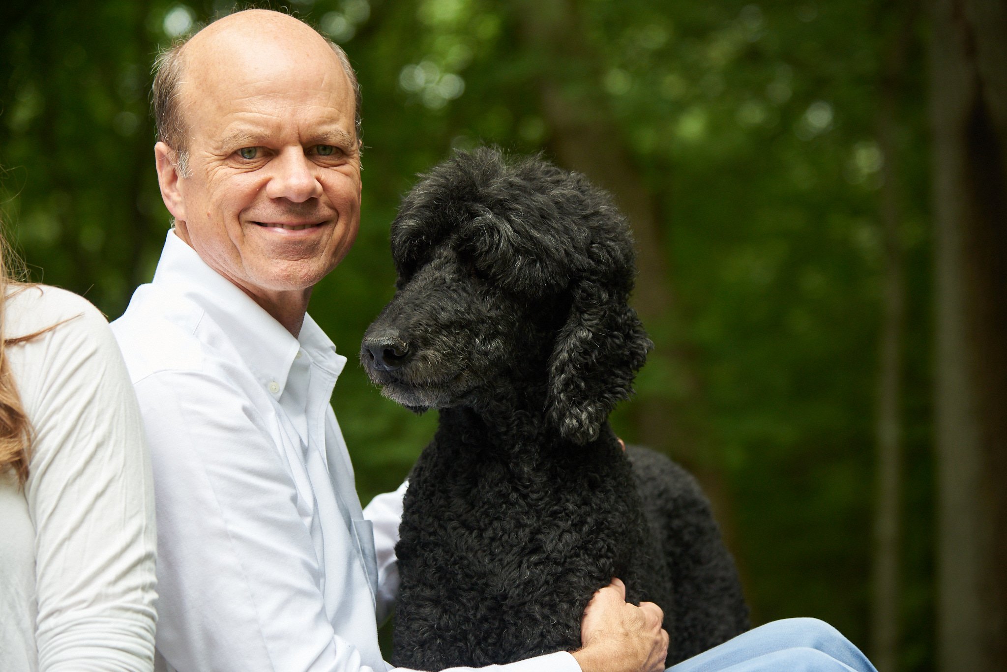 Man with his dog in backyard in Darien, CT with family photographer Pamela Einarsen.