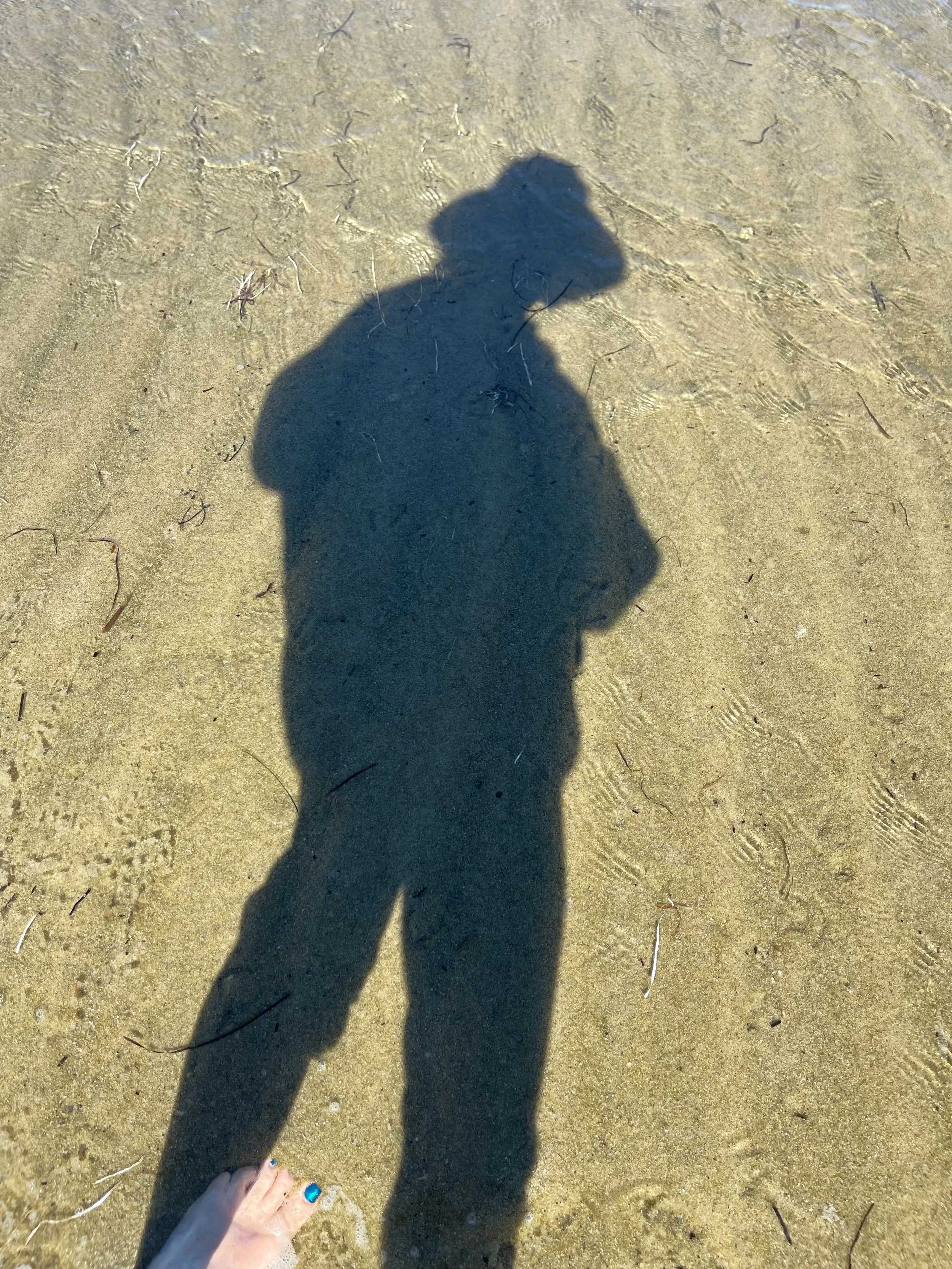 Photo of patterns in the sand at beach by family photographer Pamela Einarsen. who you see in sihouette.
