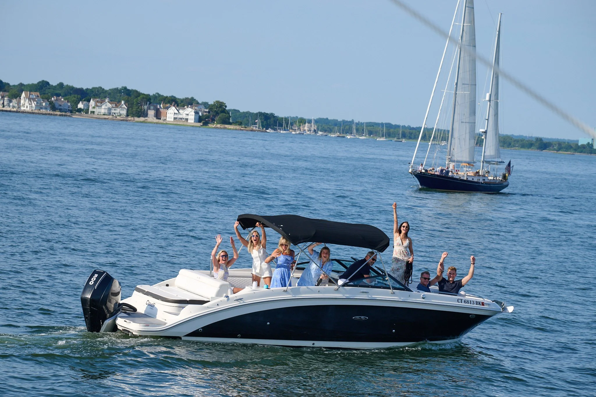Family celebrates on a boat by the Green Ledge Lighthouse after proposal in Rowayton CT by photographer Pamela Einarsen. 