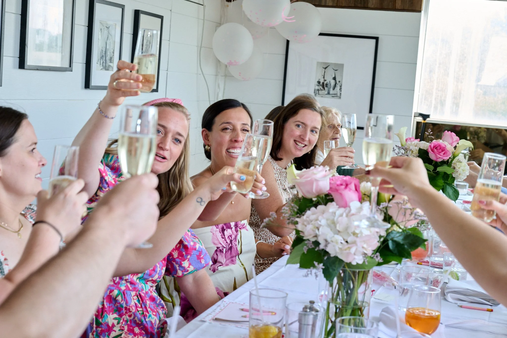 A party toasts at Rowayton Seafood in CT for a baby shower by event photographer Pamela Einarsen. 
