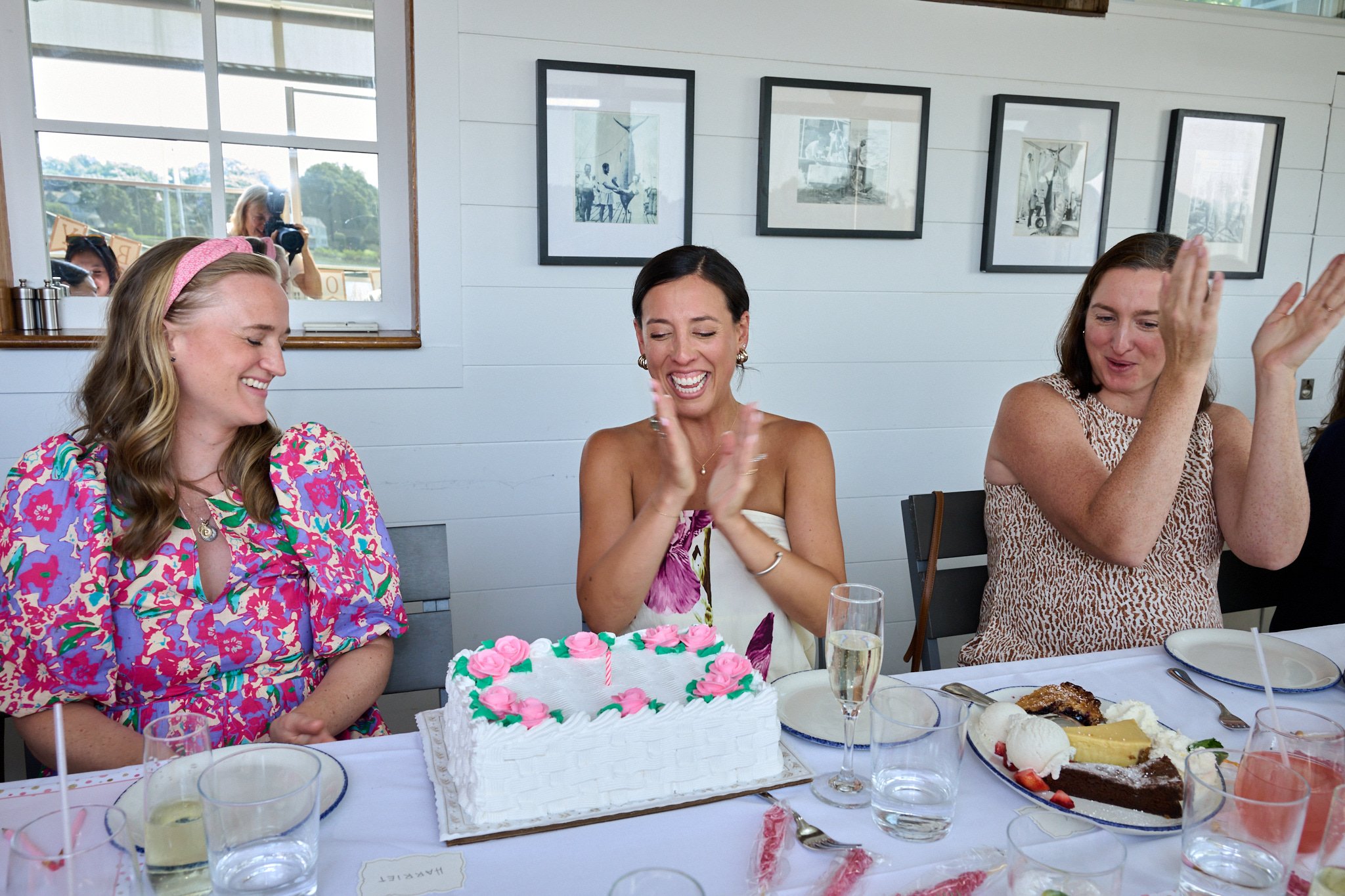 A woman celebrates with a cake at her baby shower at Rowayton Seafood in CT by event photographer Pamela Einarsen.