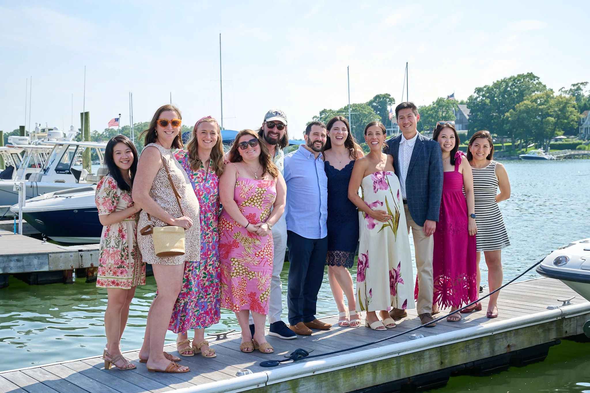 Baby shower guests pose on the dock by the water at Rowayton Seafood in CT with event photographer Pamela Einarsen. 