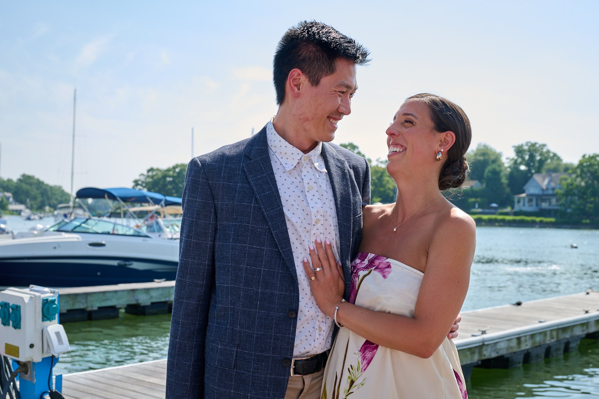 Soon to be parents hug on dock of Rowayton Seafood in CT with event photographer Pamela Einarsen. 