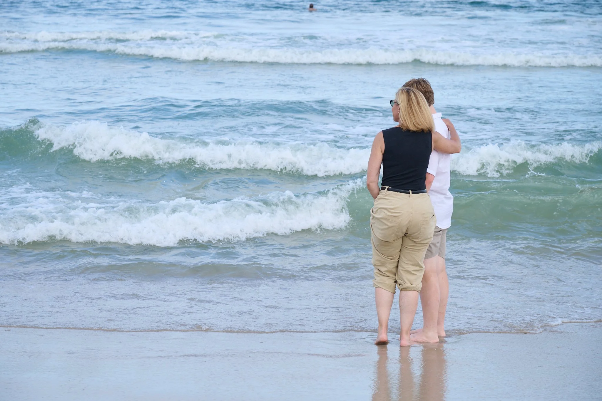 Mother puts her arm around her son while watching the waves on Long Beach Island, NJ with family photographer Pamela Einarsen.