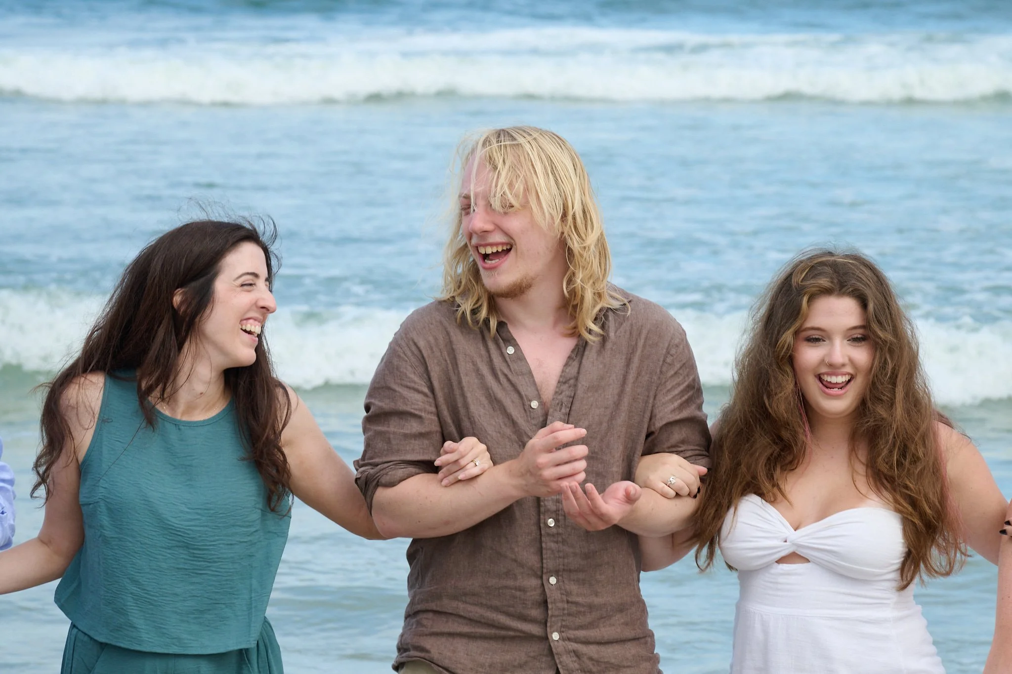 Siblings laugh holding hands on the beach in Beach Haven, on Long Beach Island with family photographer Pamela Einarsen.