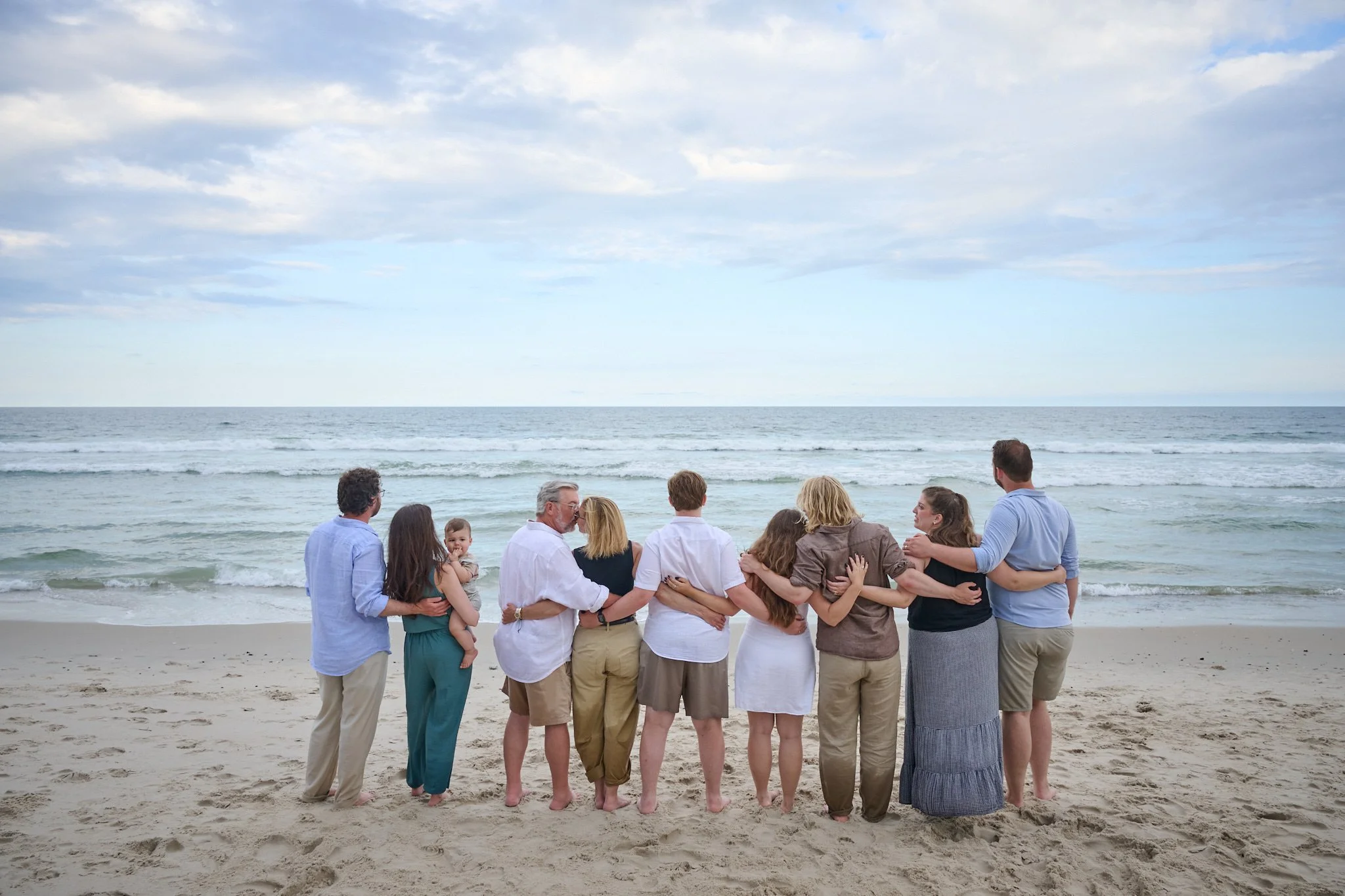 An extended family faces the ocean on Long Beach Island, NJ with family photographer Pamela Einarsen.
