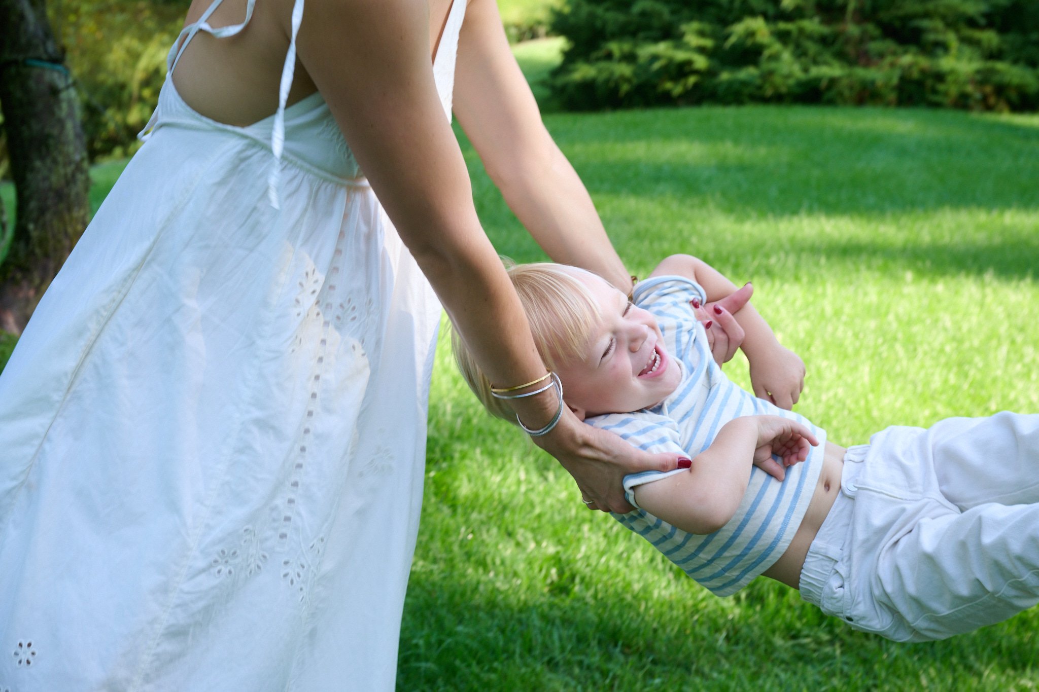 Mom swings her son in Westport CT yard by family photographer Pamela Einarsen.